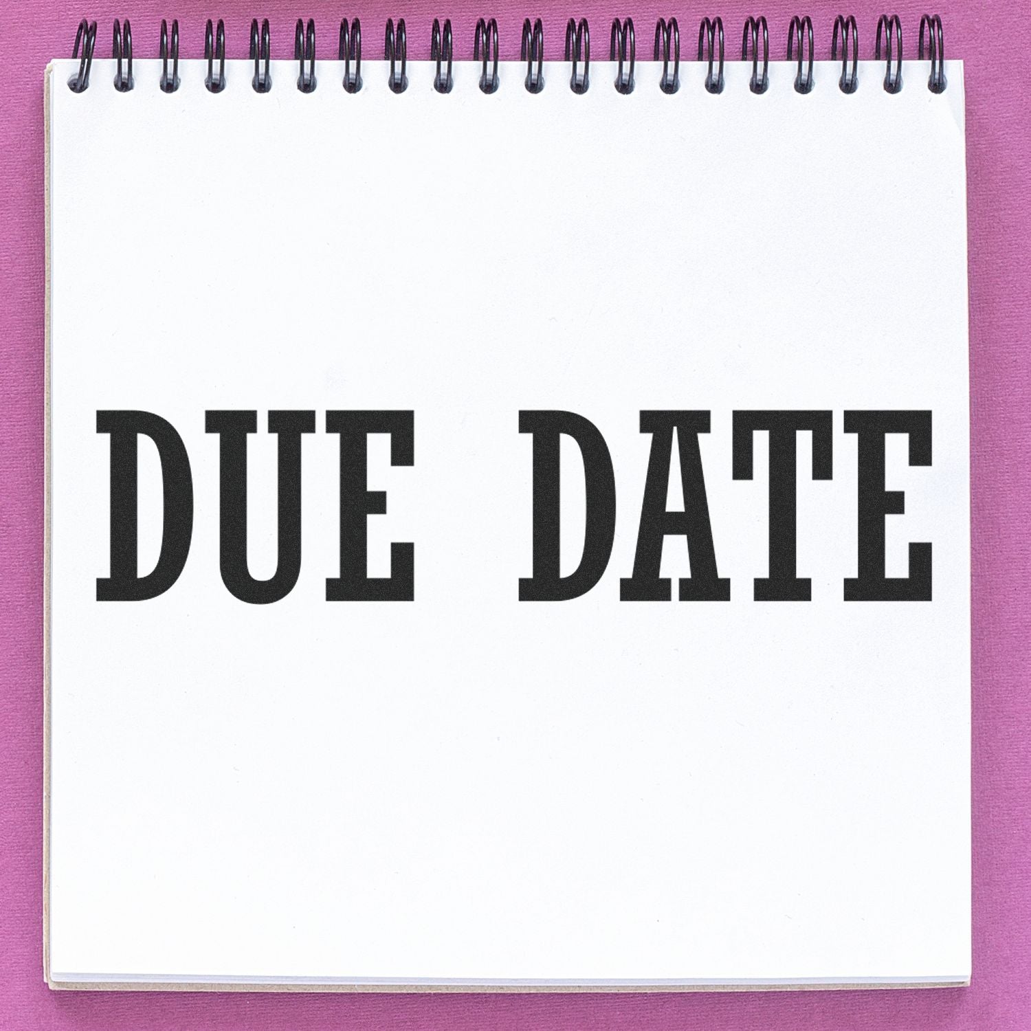 White spiral notebook cover with bold DUF DATE lettering, used for planning schedules and tracking dates on a purple background.