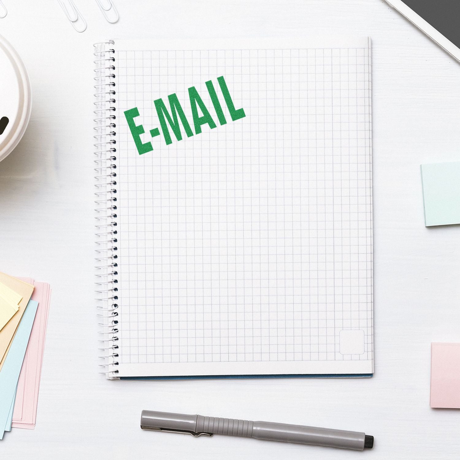 E-MAIL concept on a grid notebook with pen and stationery, illustrating email communication for marketing.