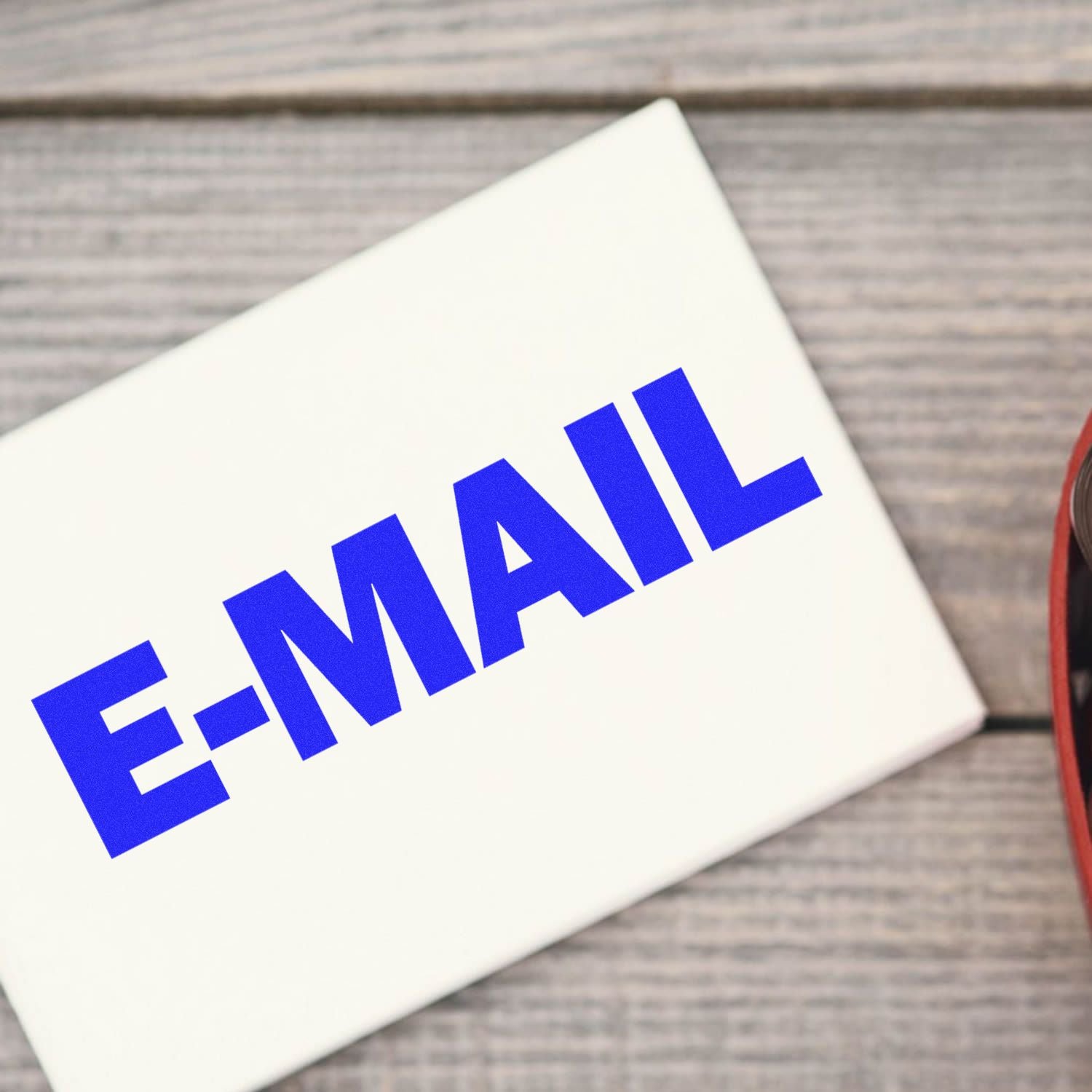 E-mail word on a white card, symbolizing email marketing and digital communication on a desk