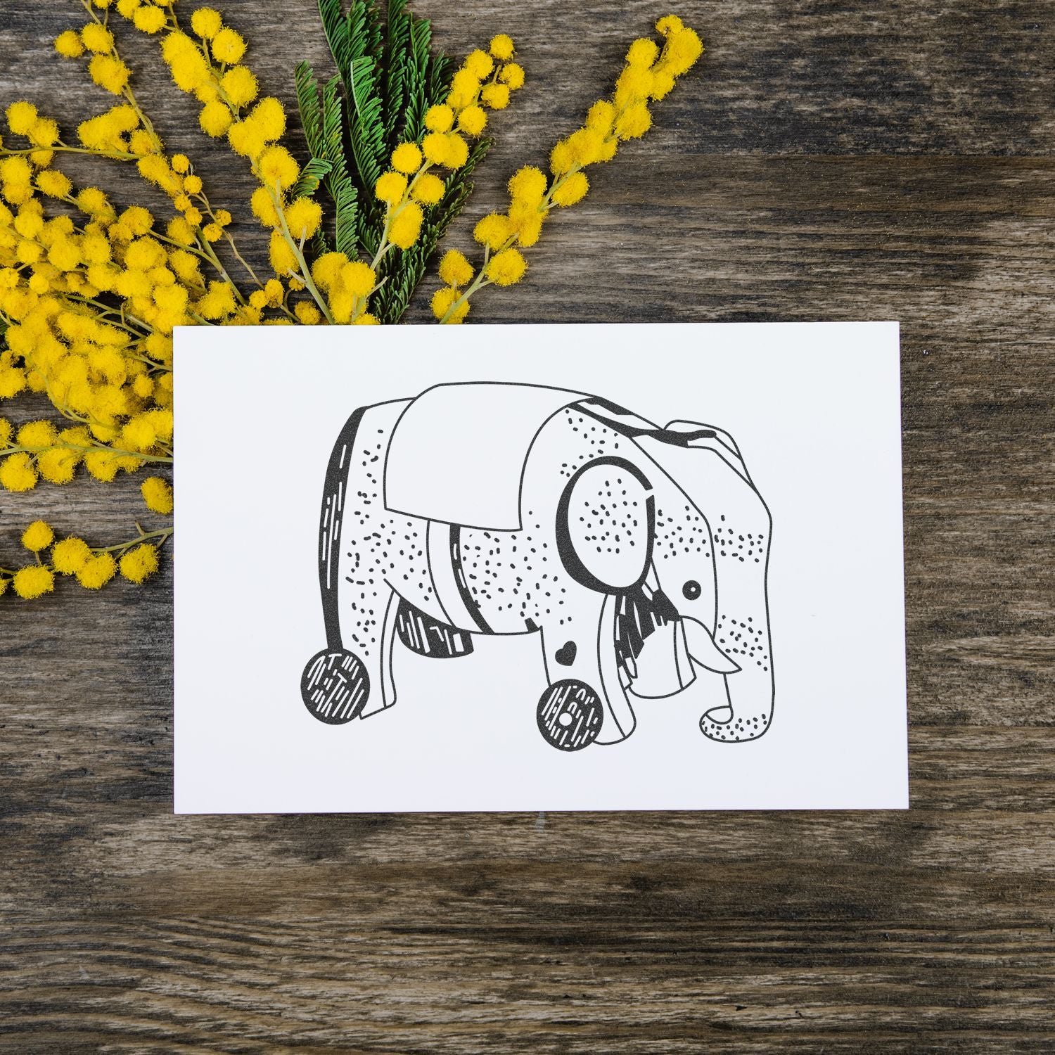 Elephant line art greeting card with yellow mimosa flowers on rustic wooden background