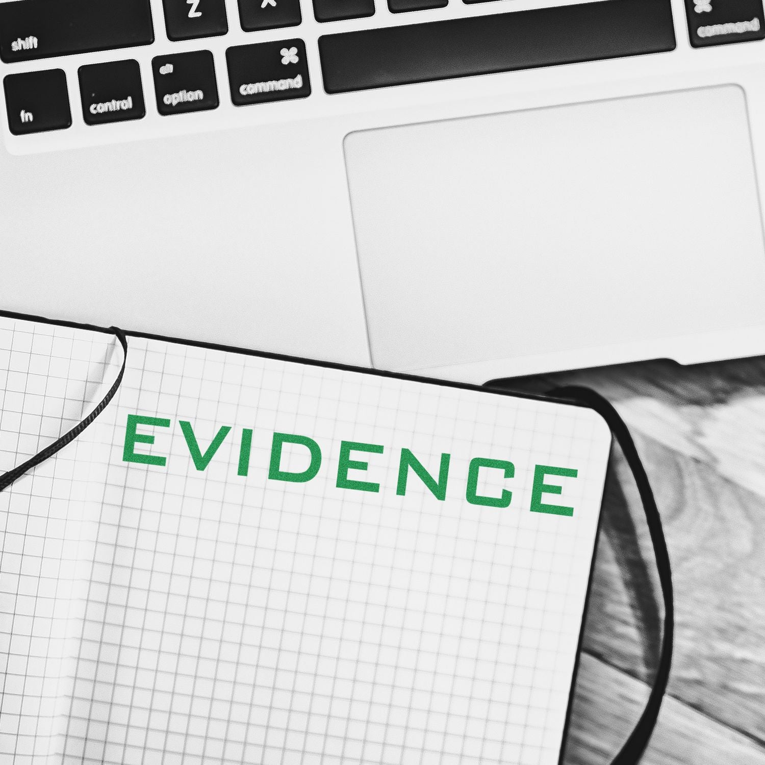 Evidence concept: notebook marked EVIDENCE with laptop keyboard, illustrating research, investigation, and legal documentation purpose.