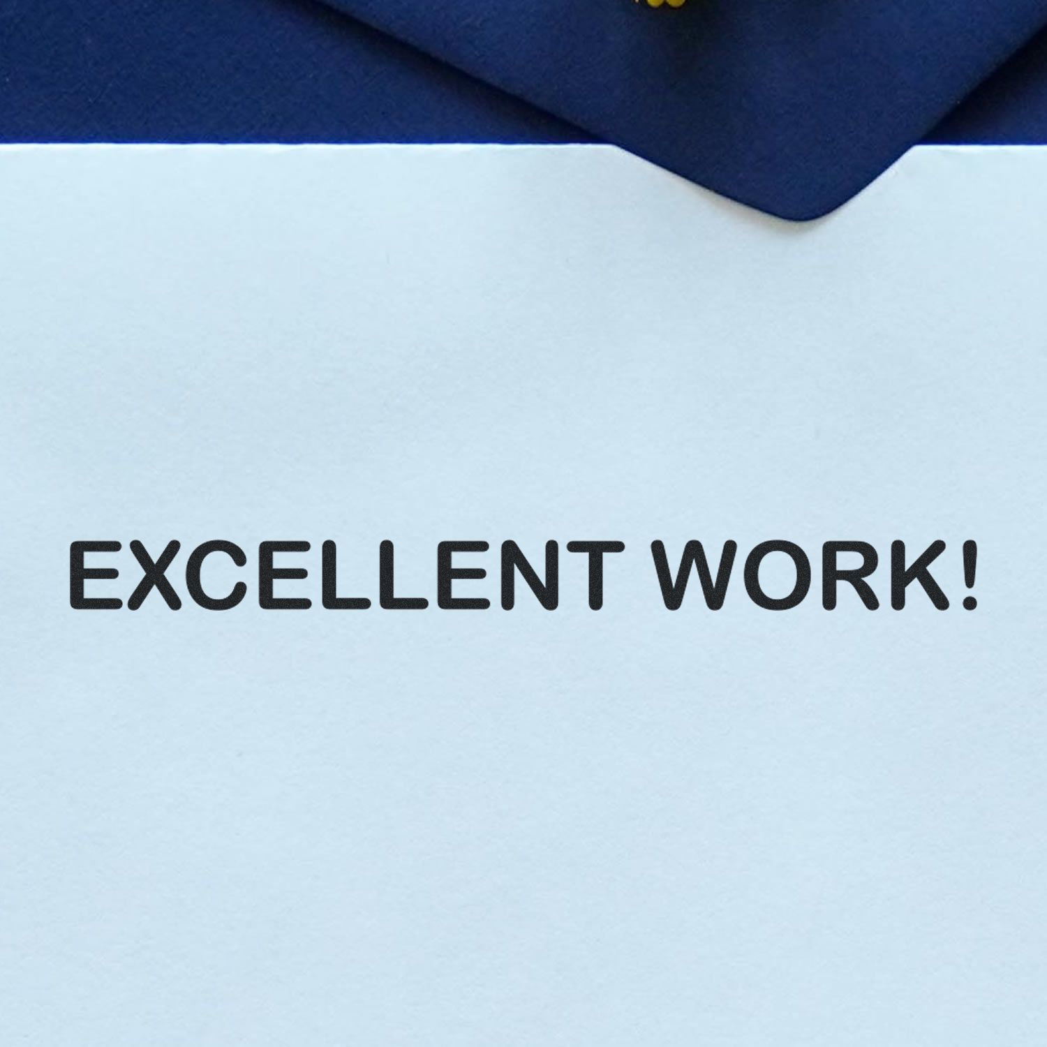 Close-up of a congratulatory note reading Excellent Work! with a blue envelope.