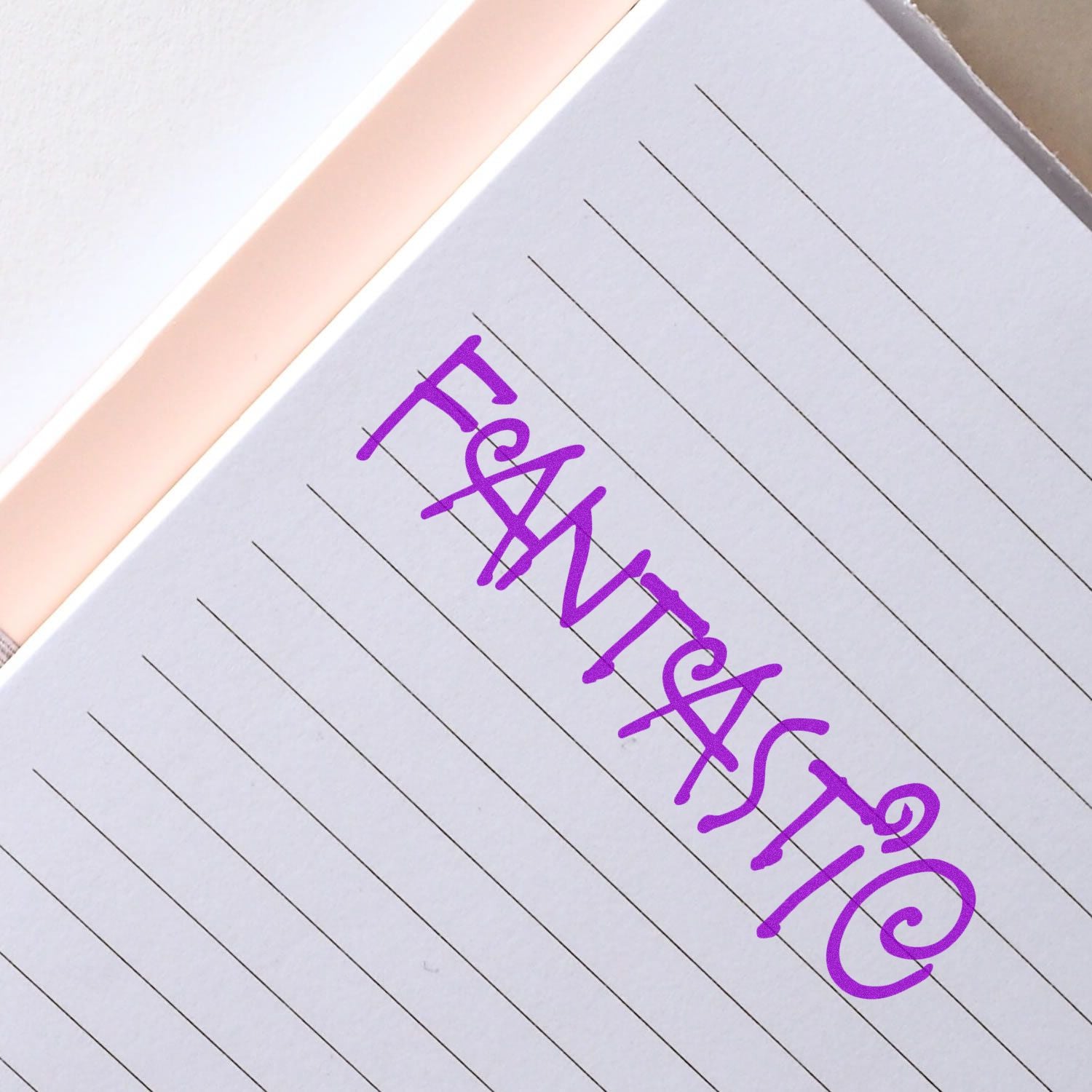 Purple handwritten fantastic on lined notebook paper, close-up stationery background.