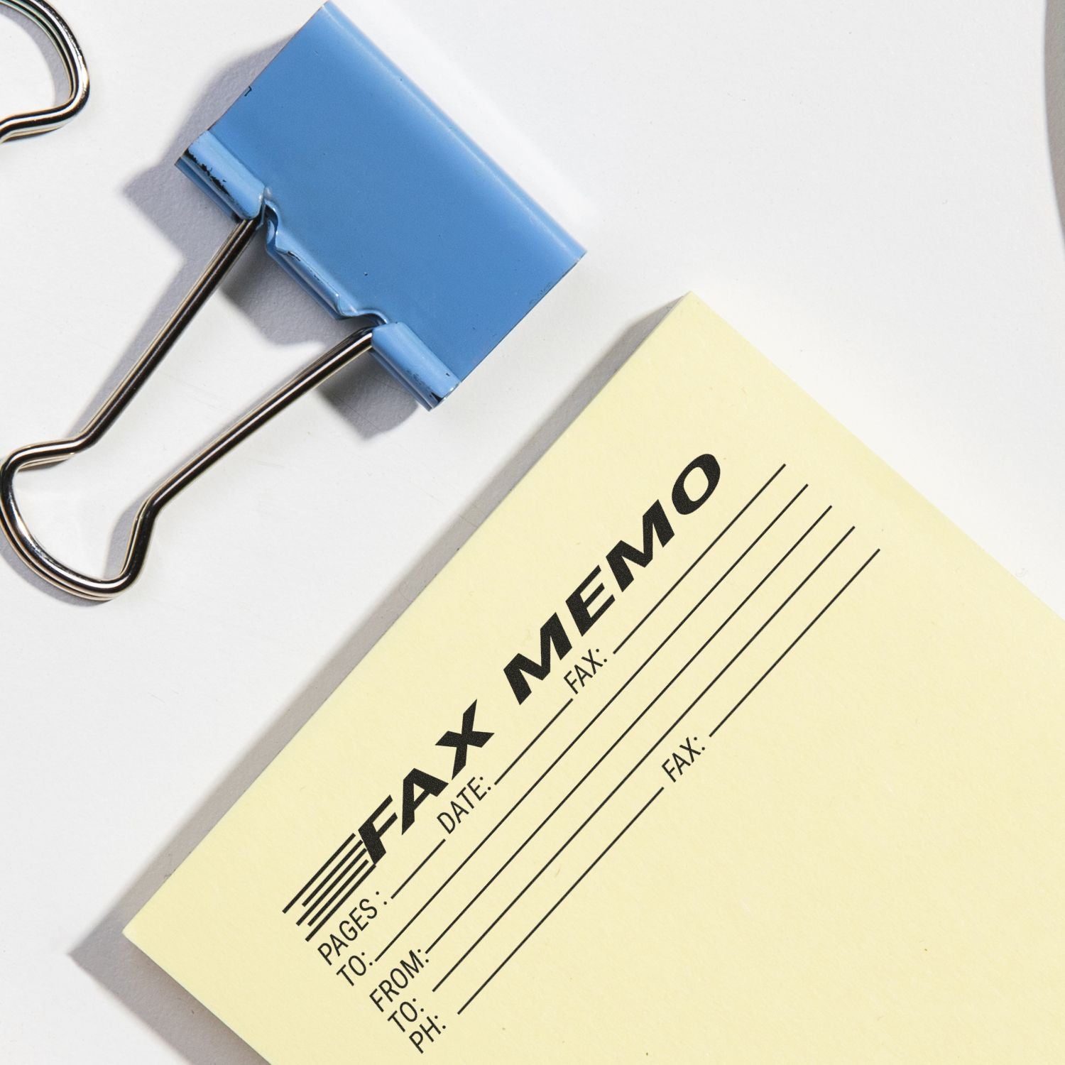 Blue binder clip secures a fax form, highlighting business communication fields like recipient, date, and pages for fast document transmission.