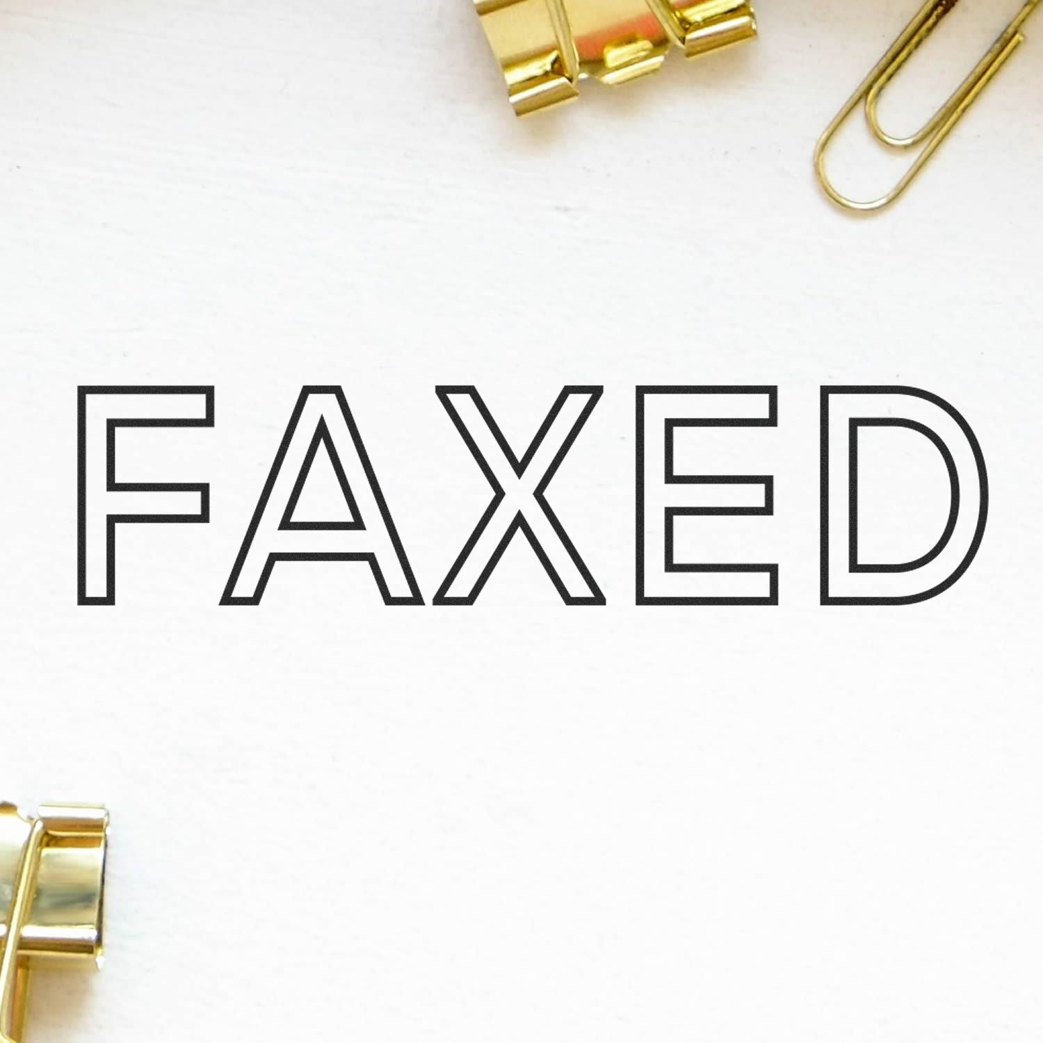 FAXED text on white paper with gold binder clips, highlighting document faxing and office communication branding for business document transmission.