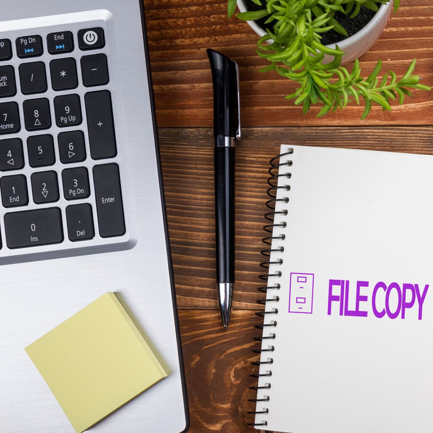 File copy concept with laptop keyboard, pen, and notebook on desk, showing document copying and office productivity tools.