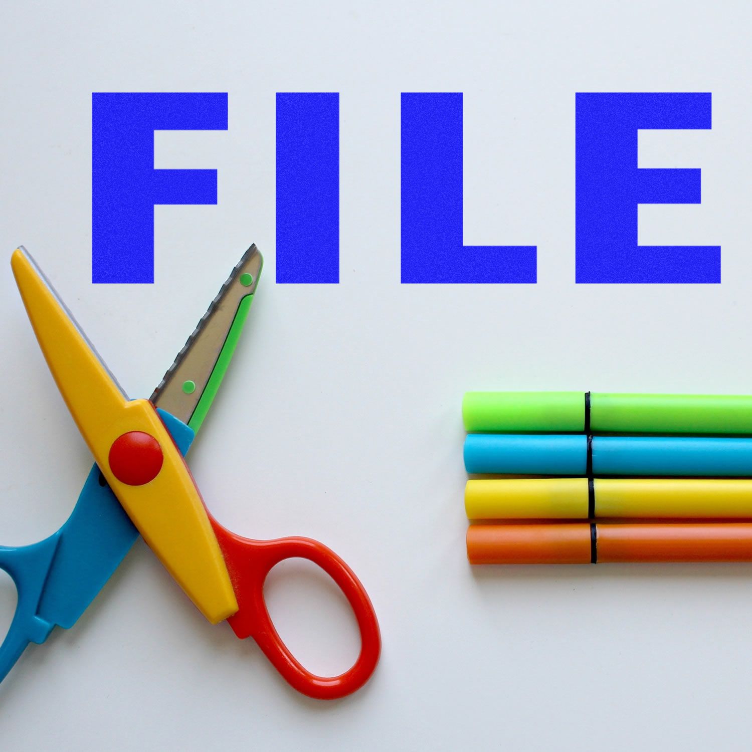Blue FILE text with colorful scissors and markers on a white background, office and craft supply concept.