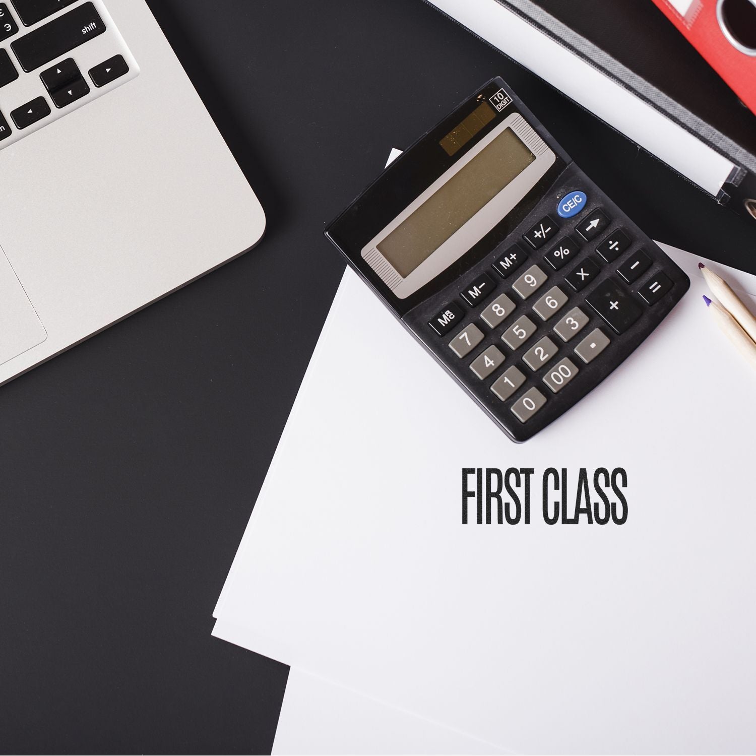 Laptop, calculator, and First Class document on a modern office desk for business accounting and finance planning.