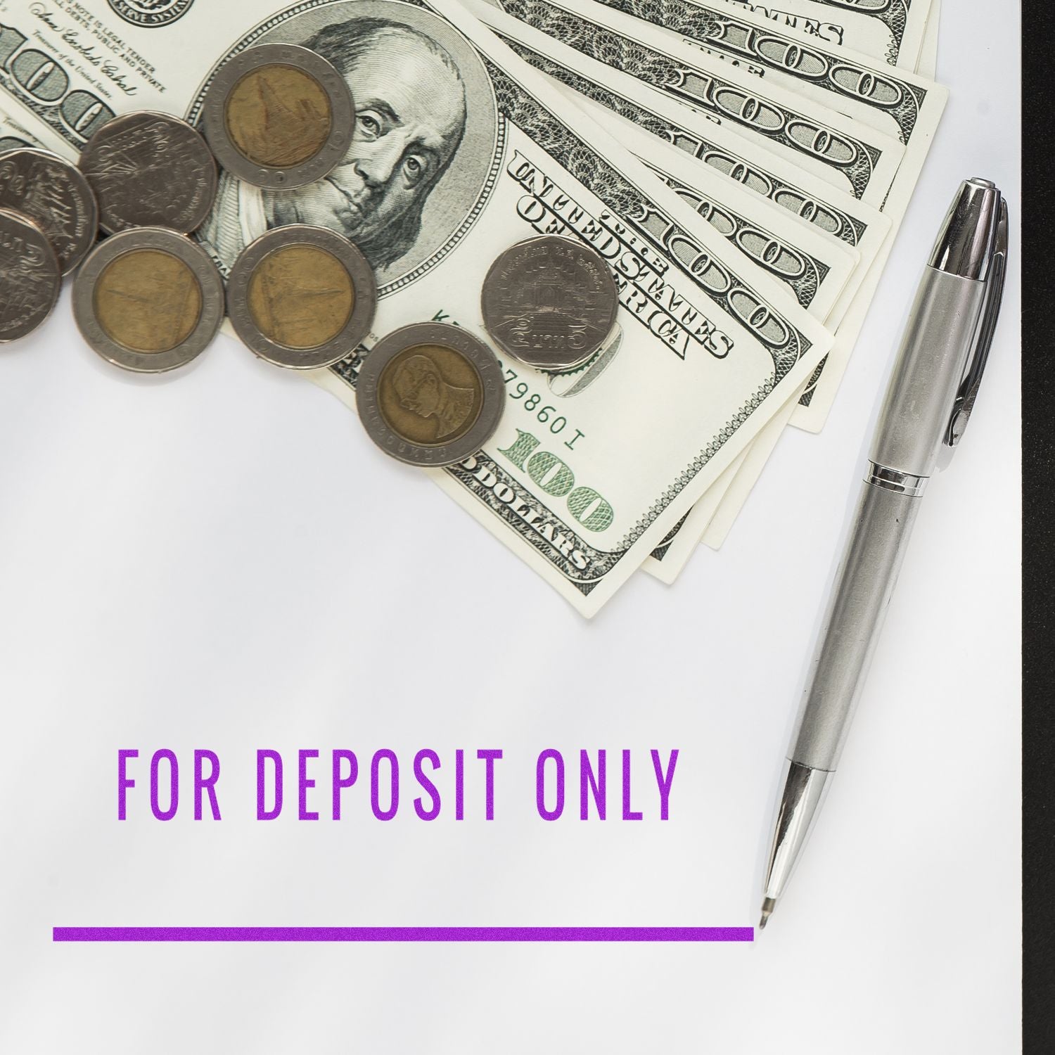 For deposit only check with U.S. dollar bills, coins, and pen on white background, banking and finance concept.