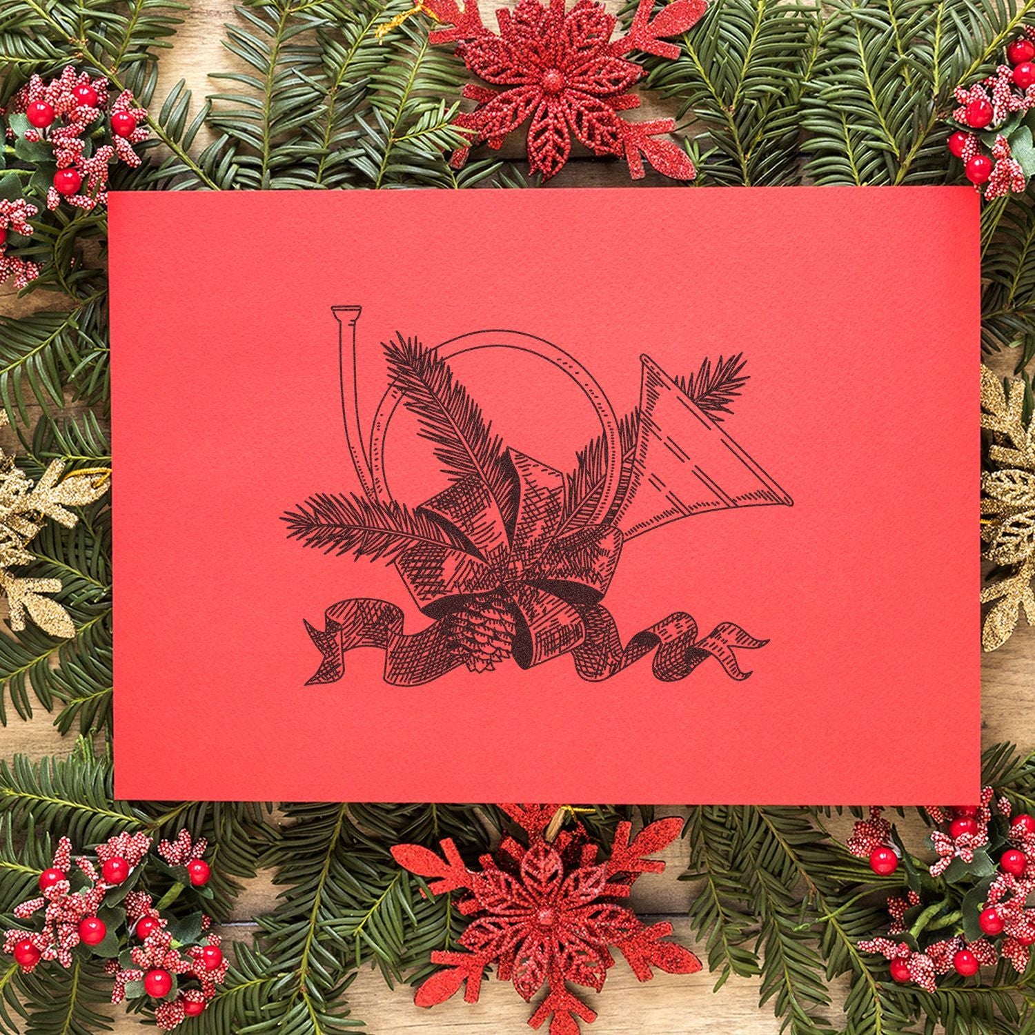 Festive red Christmas greeting card with vintage black holiday ornament illustration, surrounded by evergreen branches, berries, and snowflake decorations.