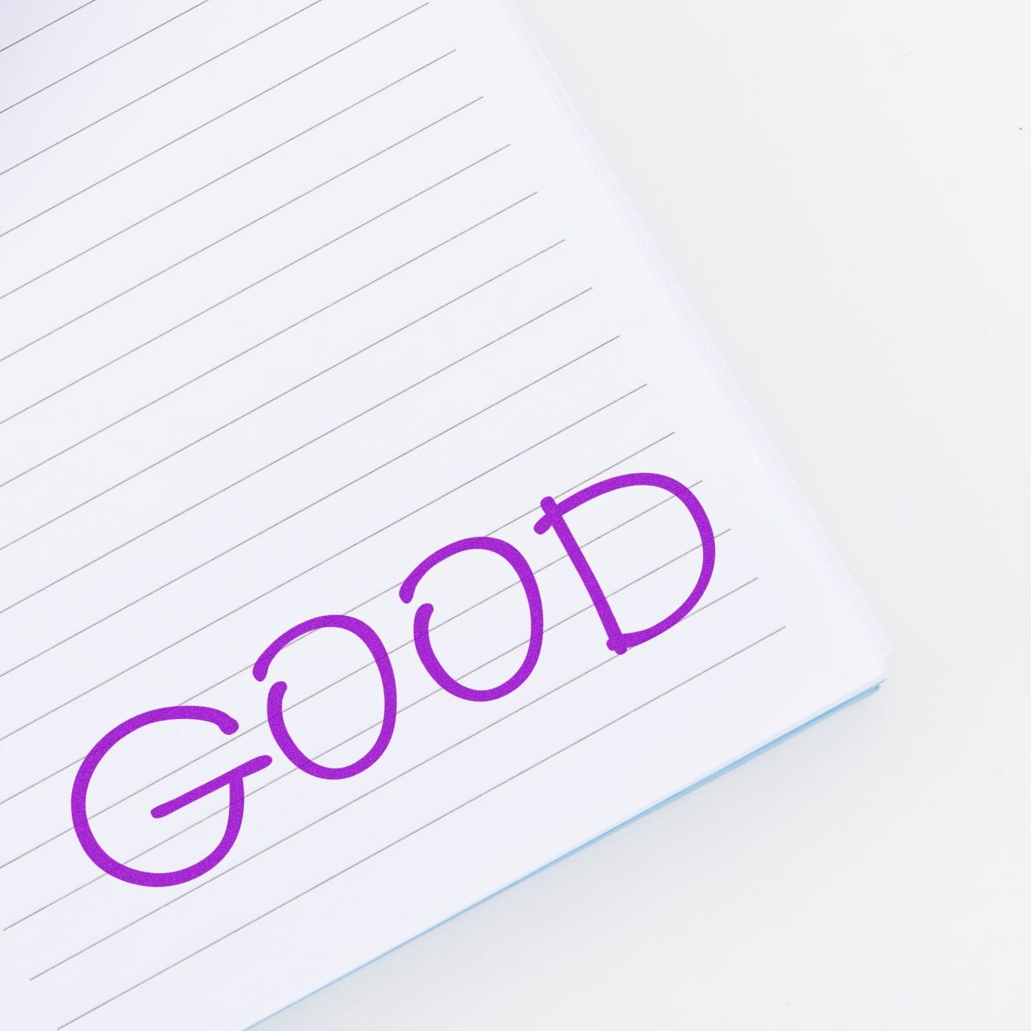 Purple GOOD handwritten on lined notebook paper, symbolizing positivity, motivation, and productivity.