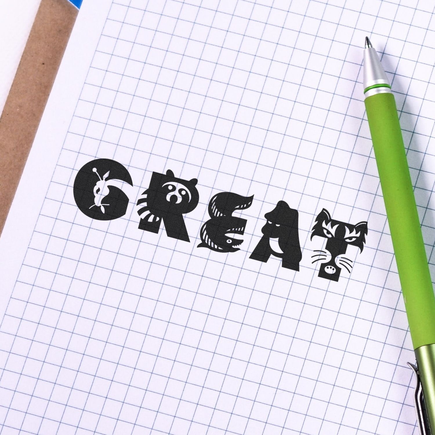 Stylized GREAT typography on graph paper notebook with a green pen, creative school stationery design.