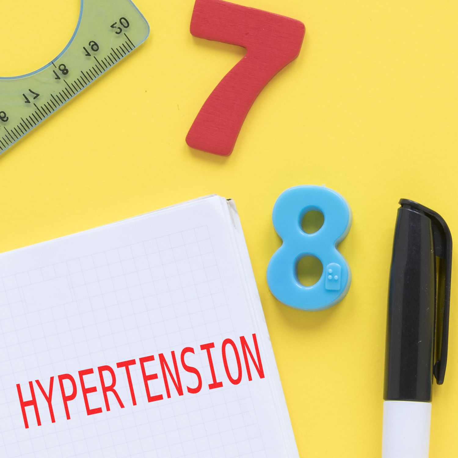 Hypertension awareness flat lay with measuring tape, pencil, and number 8 on yellow background.