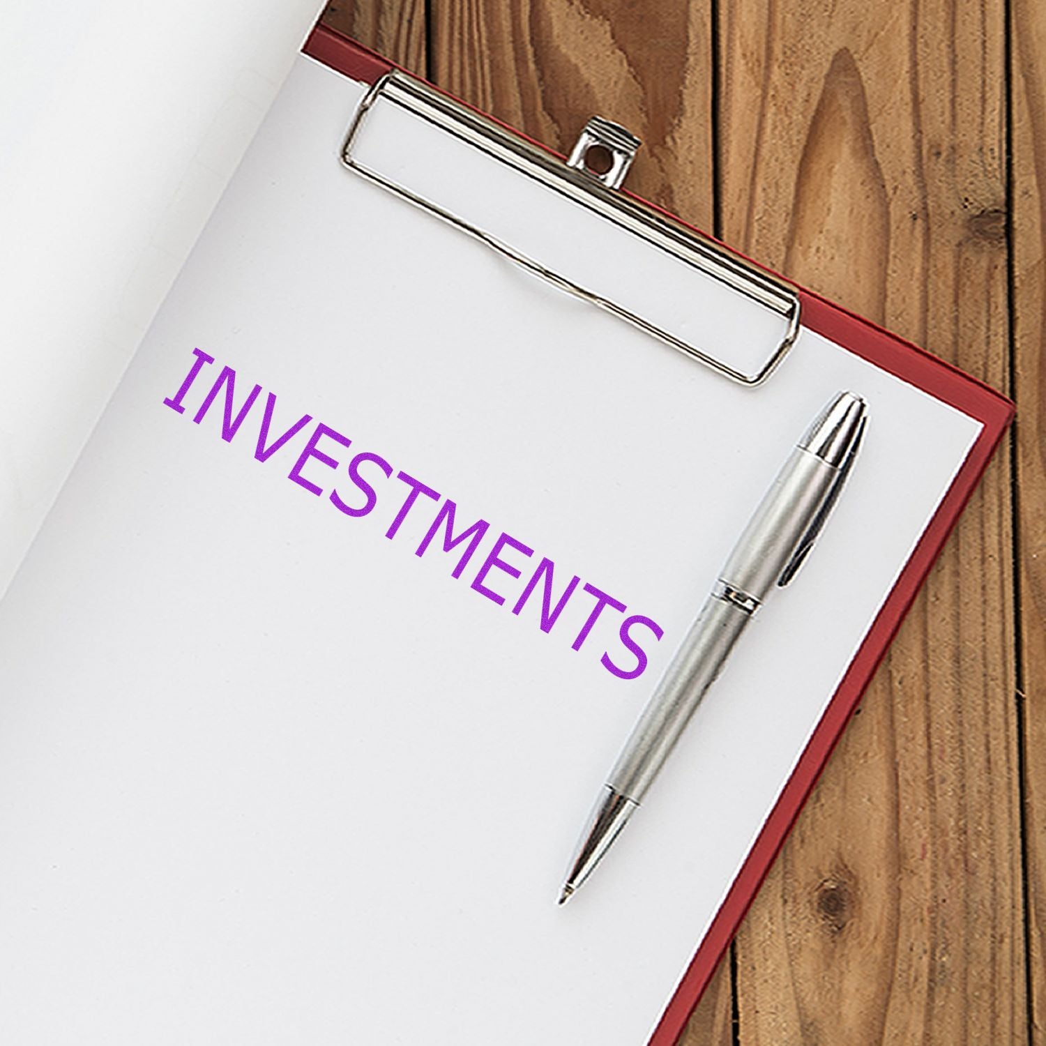 Investments planner clipboard with pen and binder clip, used for financial planning, portfolio tracking, budgeting goals, and return management.