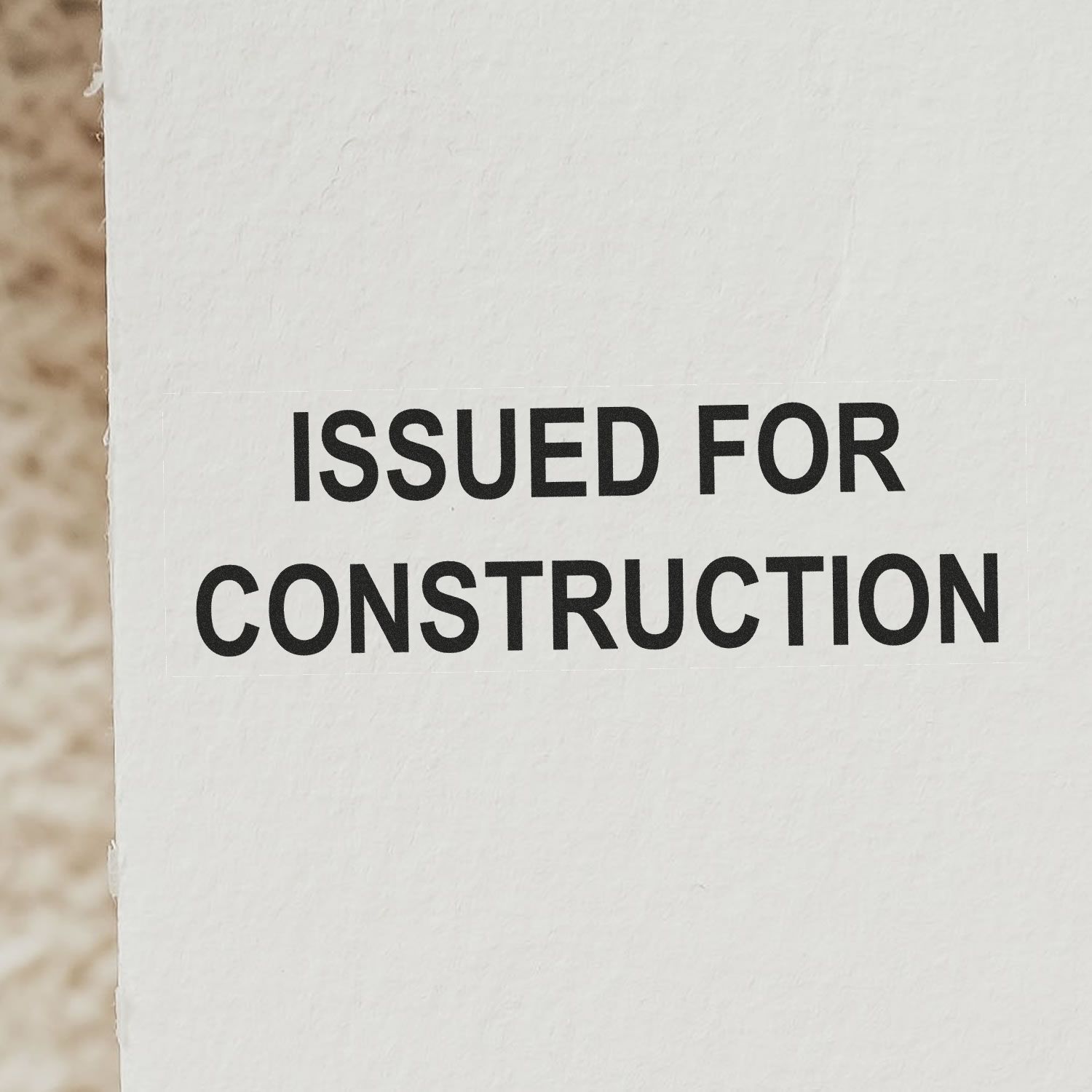 Issued for Construction stamped on white paper document, close-up of construction drawing approval notice.
