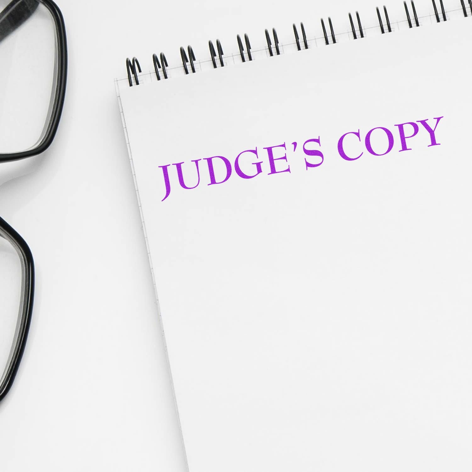 Legal judge's copy notebook with eyeglasses showing the words JUDGE'S COPY, symbolizing court case documentation for lawyers and judges.