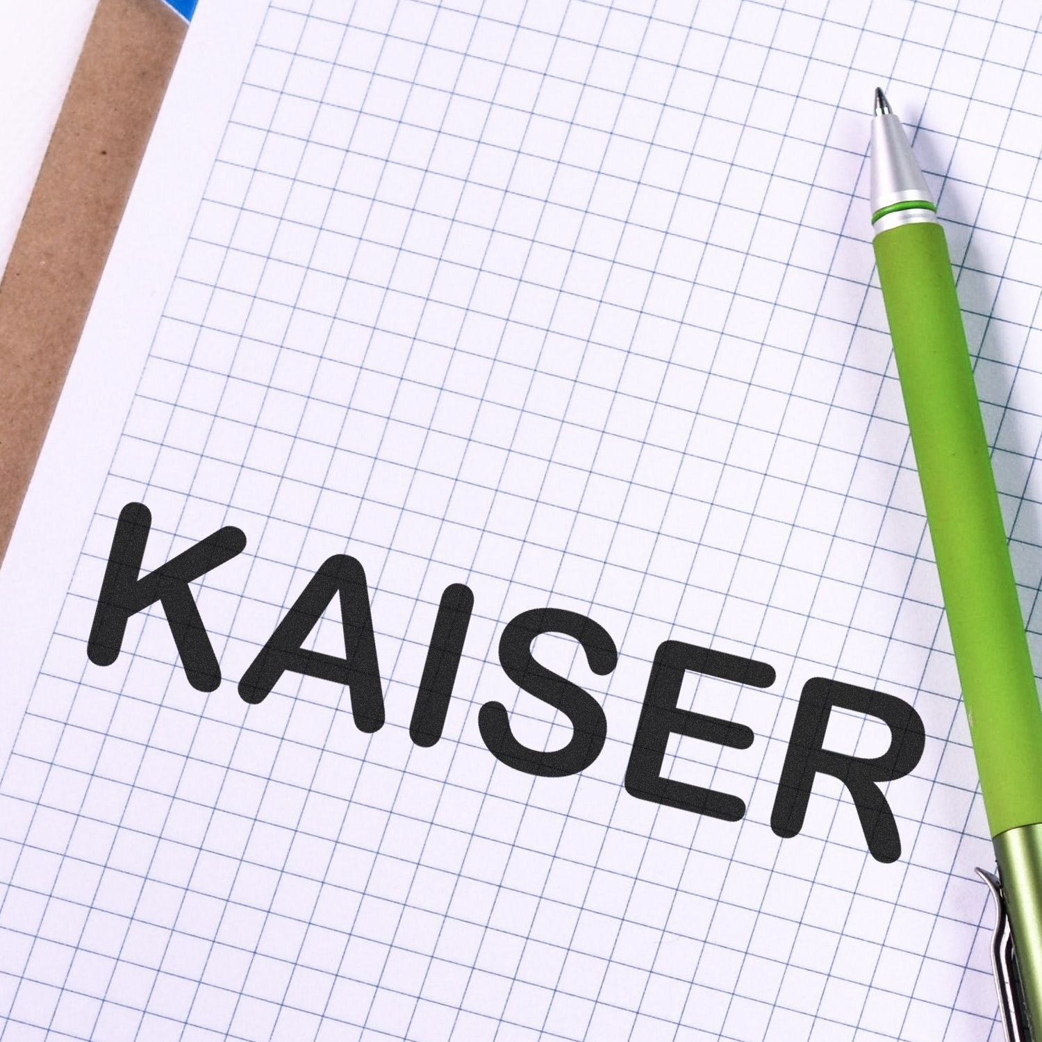 Kaiser handwriting on graph paper with green pen, highlighting notes, planning, and writing for business goals.
