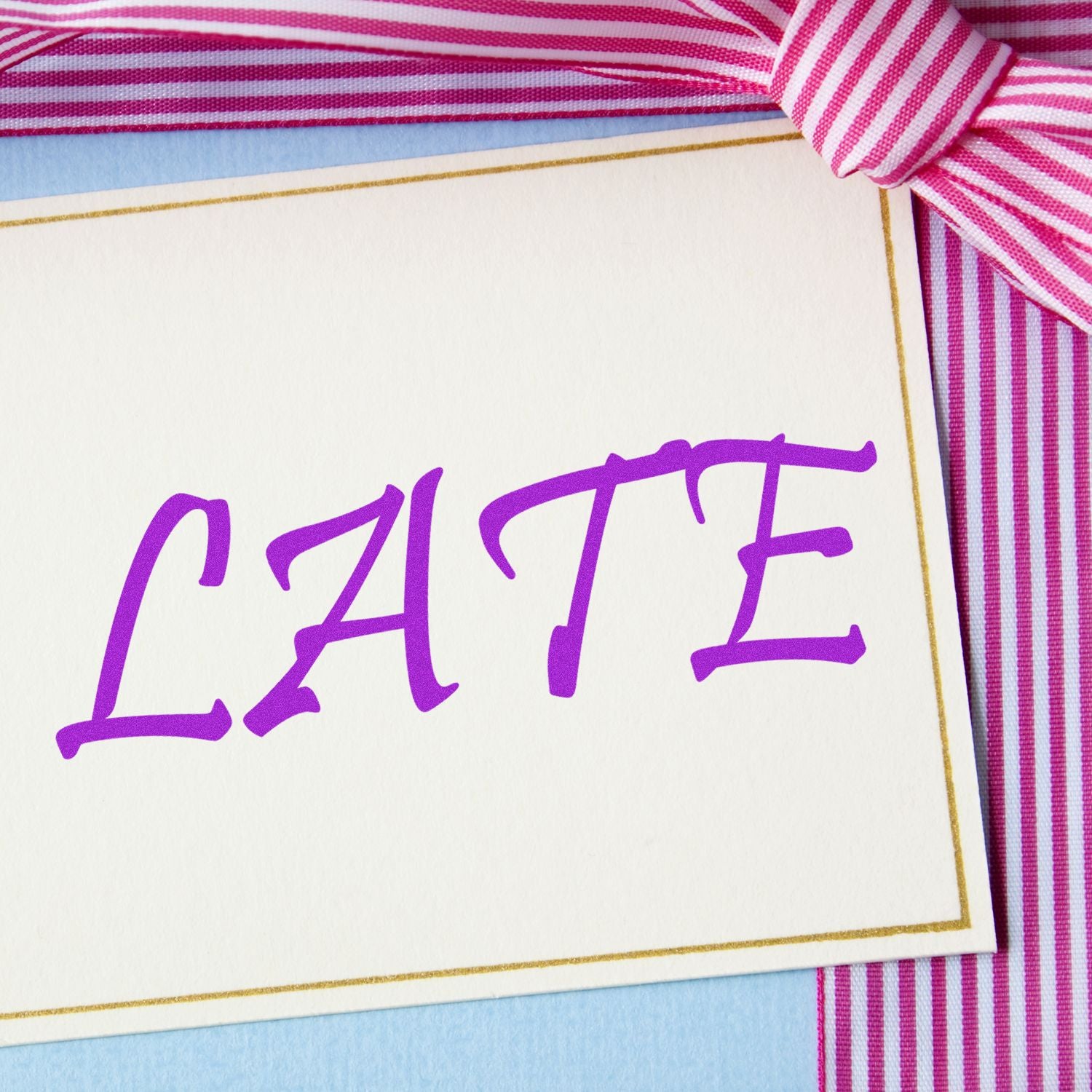 Personalized gift card with purple CATE lettering and pink striped ribbon decoration.