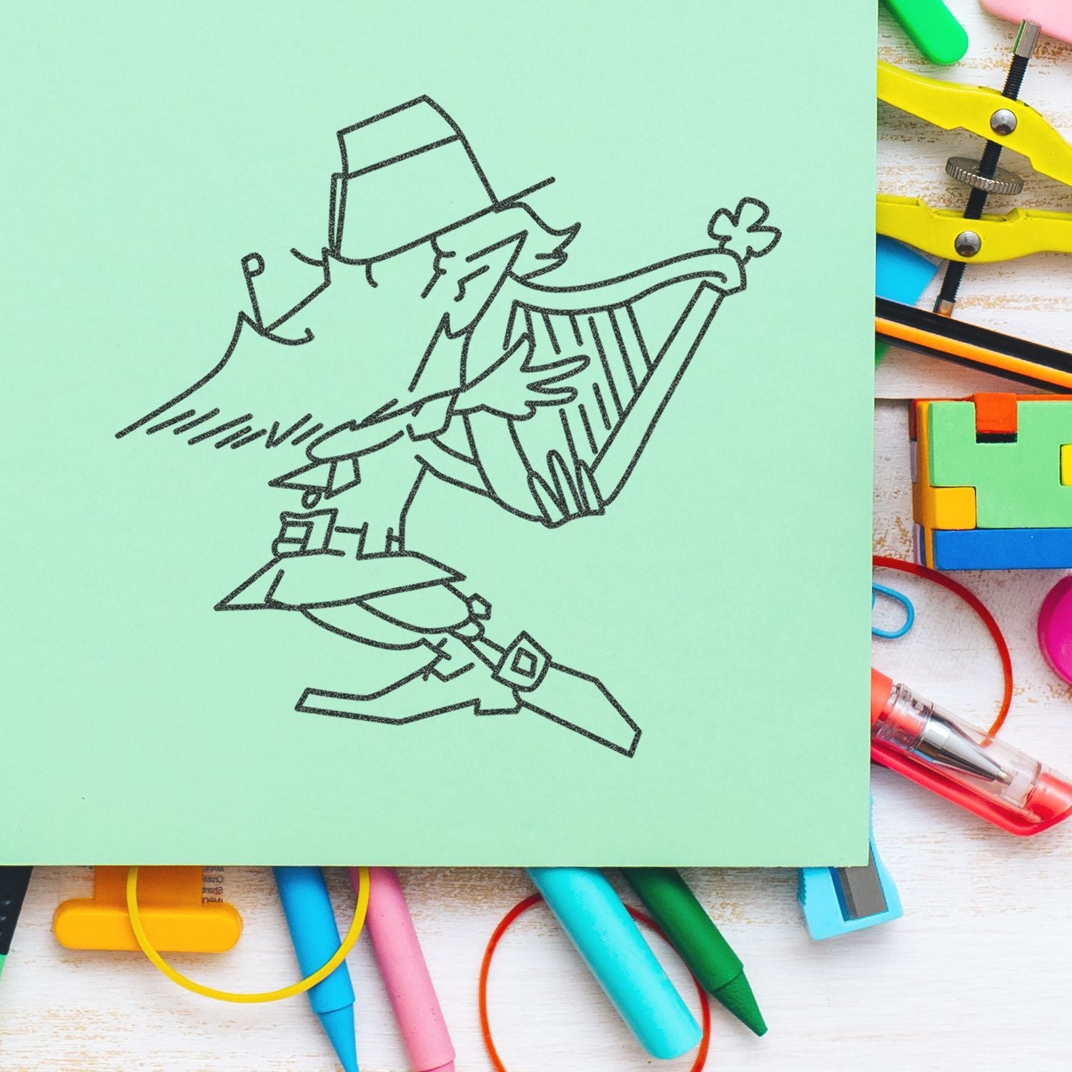 Hand-drawn detective sketch on mint green paper with colorful stationery and pens on a desk