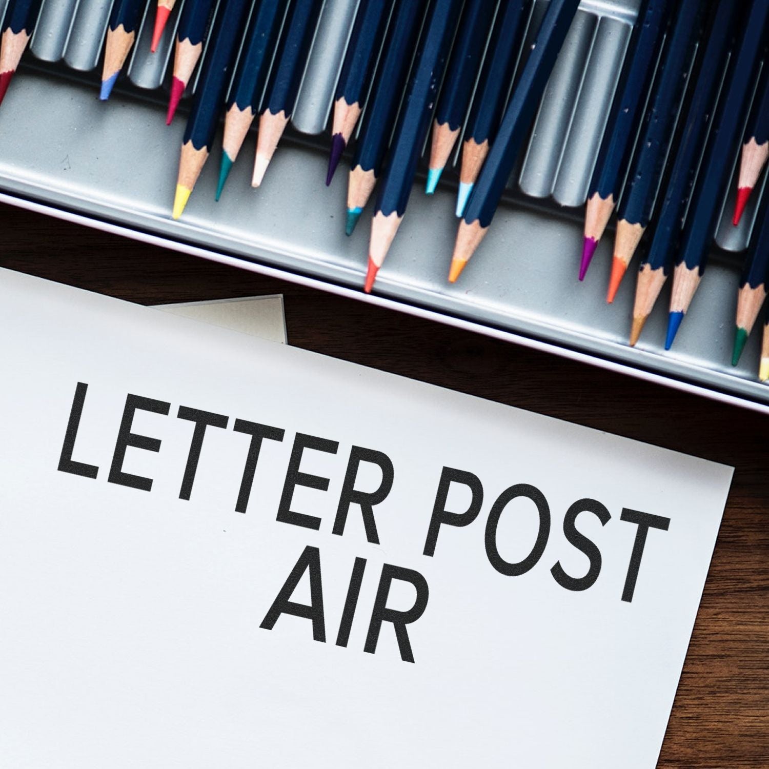 Letter post air label with colored pencils on a desk, creative writing and stationery concept