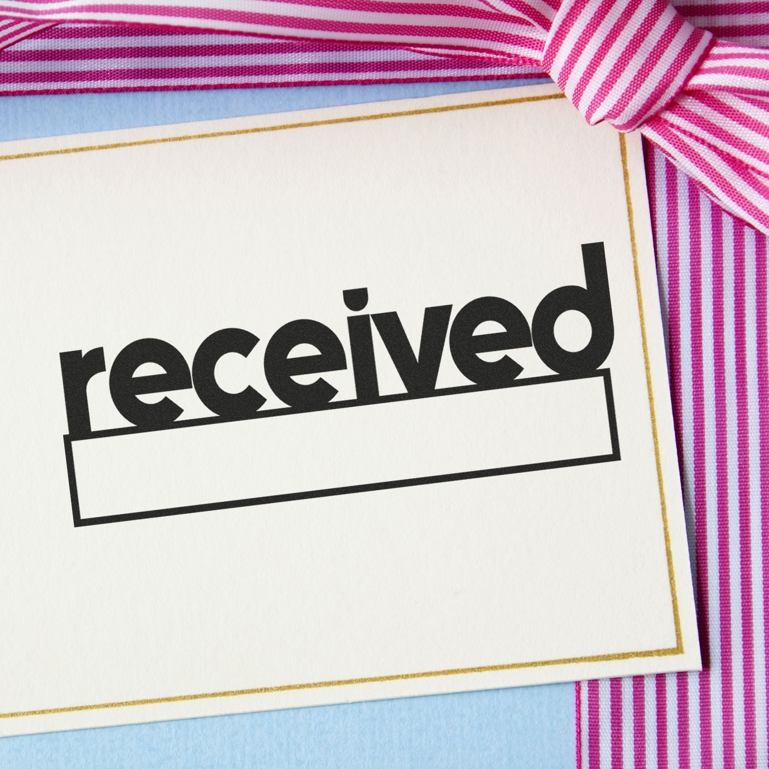Received gift card with pink striped ribbon on a pastel background.