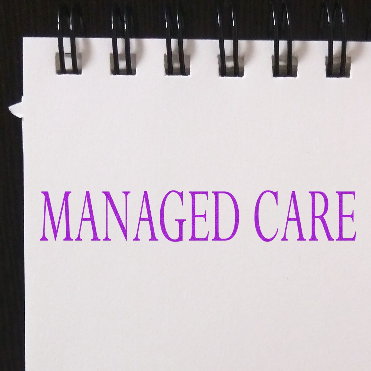 Spiral-bound notebook page with Managed Care written in purple text on a white background.