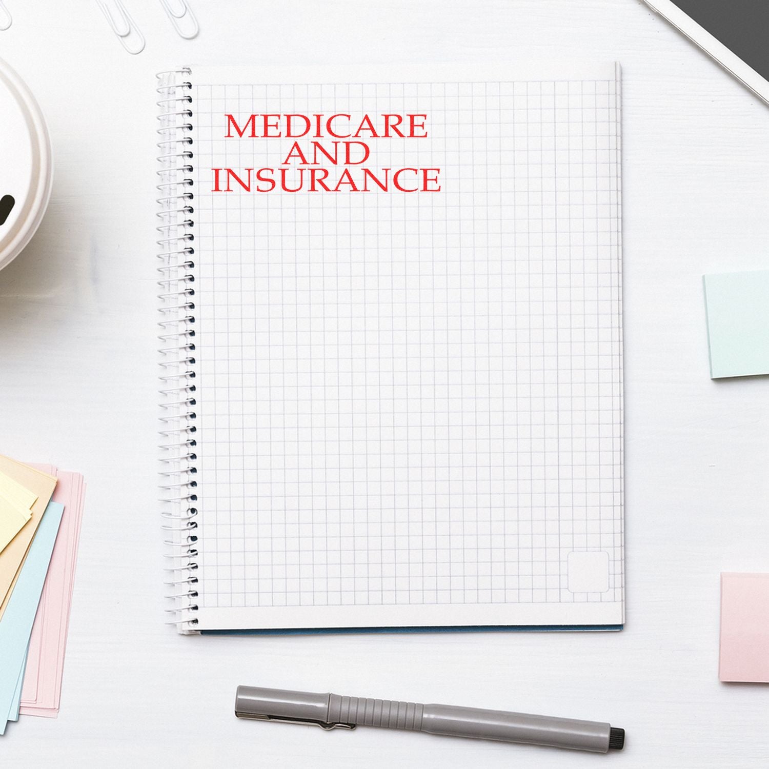 Notebook titled Medicare and Insurance on office desk, illustrating health coverage and Medicare insurance planning.
