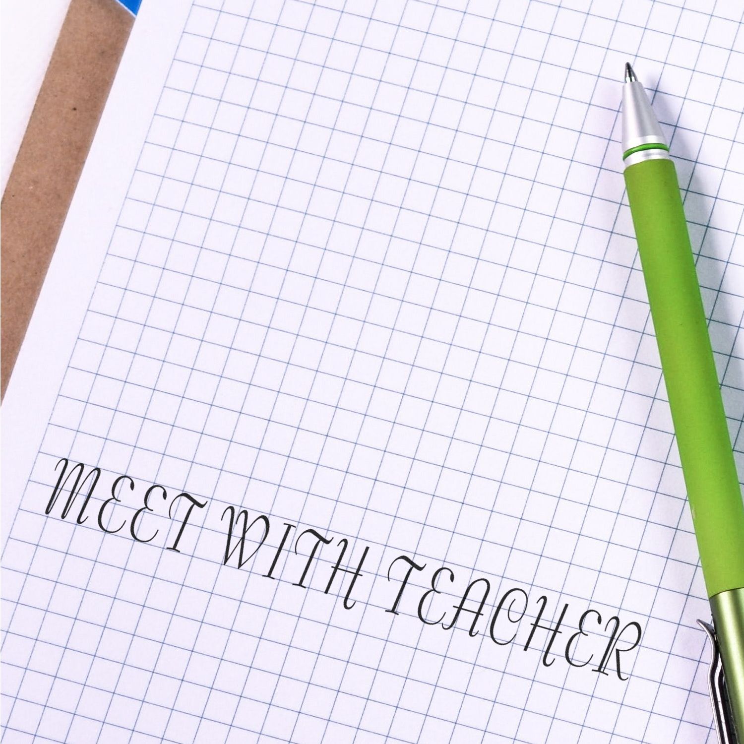 Green pen on blue grid paper with handwritten text, illustrating note-taking, planning, and writing on graph paper