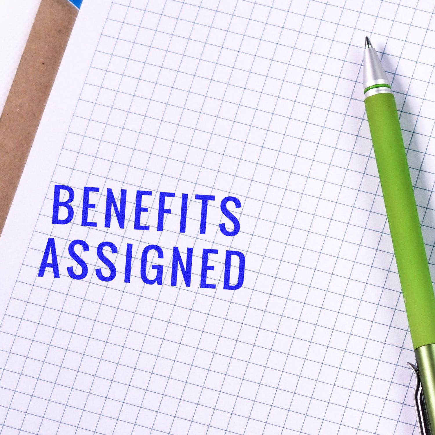 Graph paper with green pen and Benefits Assigned text, illustrating benefit allocation tracking and assignment in documentation.