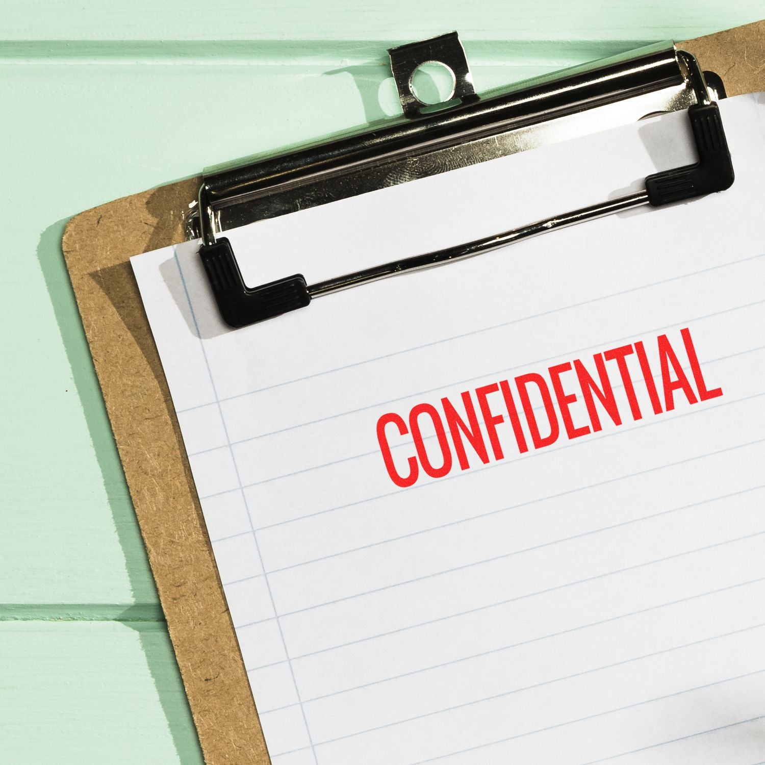 Clipboard with red CONFIDENTIAL label, representing secure document handling for sensitive information and privacy protection.