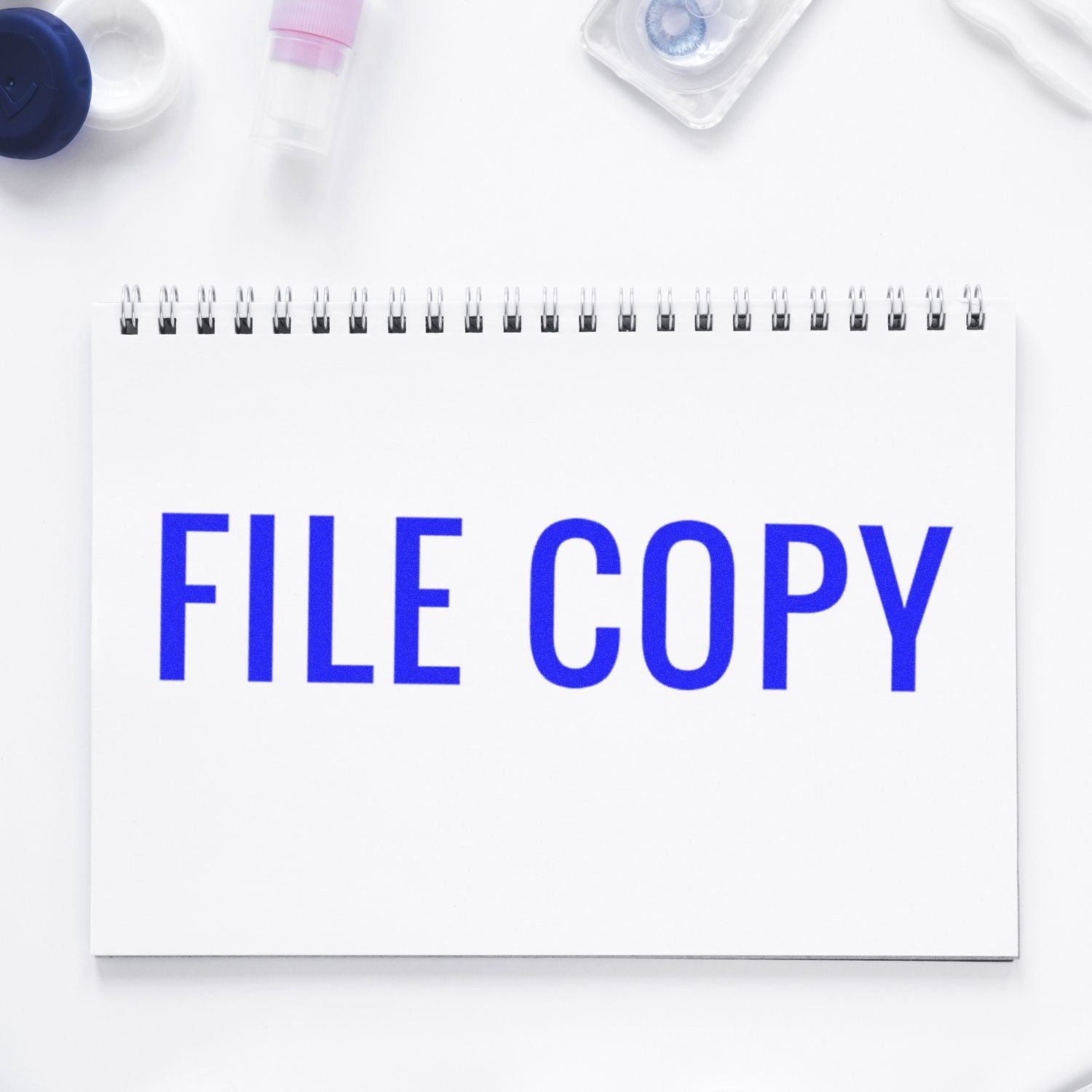 Blank spiral notebook with FILE COPY text on a white desk, office document storage concept.