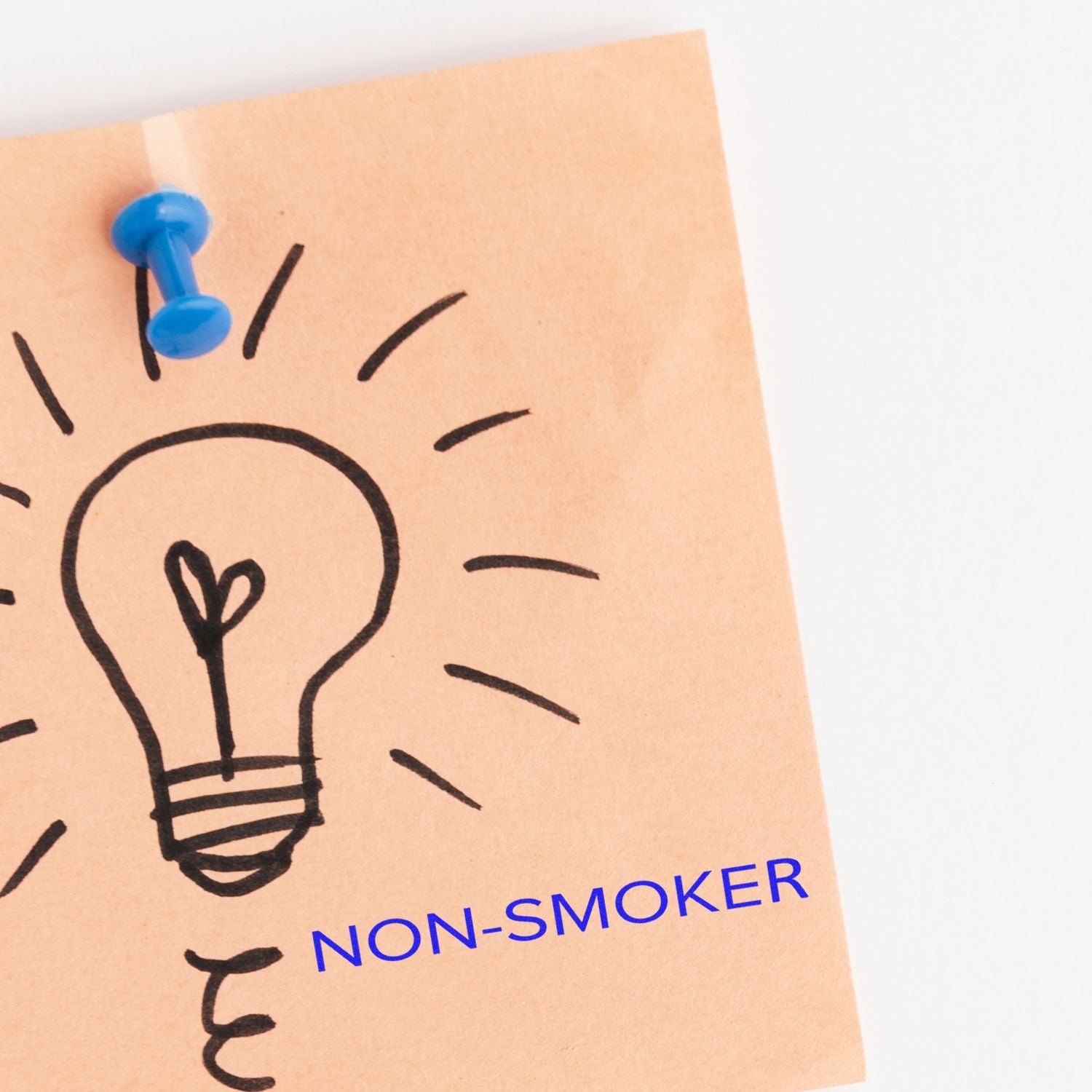 Pinned non-smoker notice with lightbulb icon, showing a smoke-free, non-smoking policy for workplaces or events.