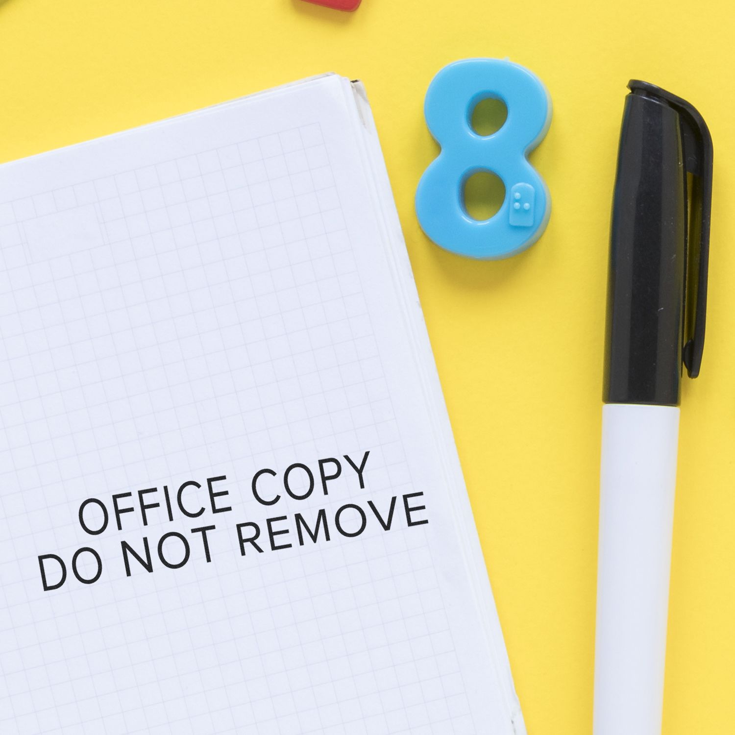 Office copy label Do not remove on notepad with pen, highlighting document control and office security