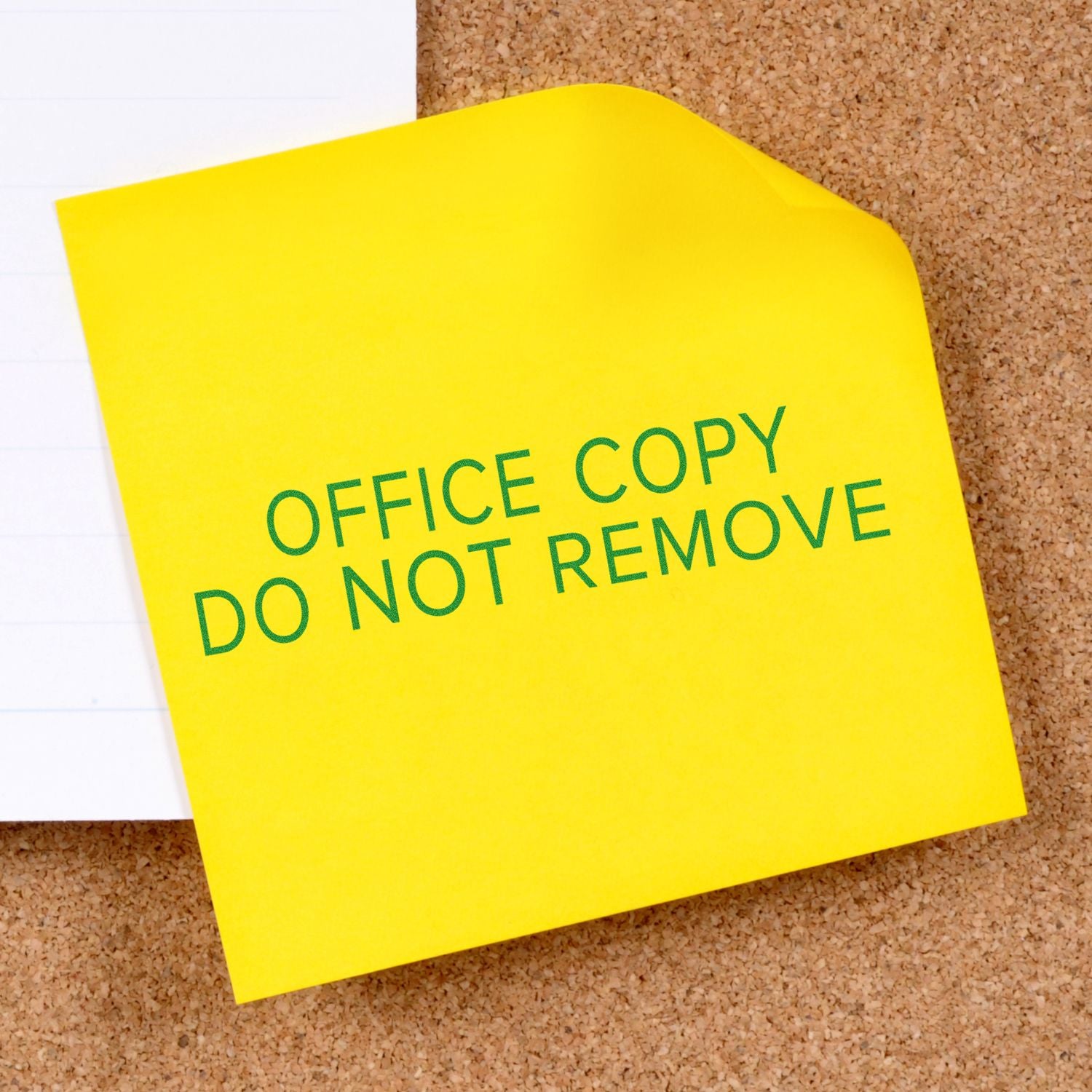 Yellow sticky note on cork board: Office Copy Do Not Remove warning not to remove office documents.