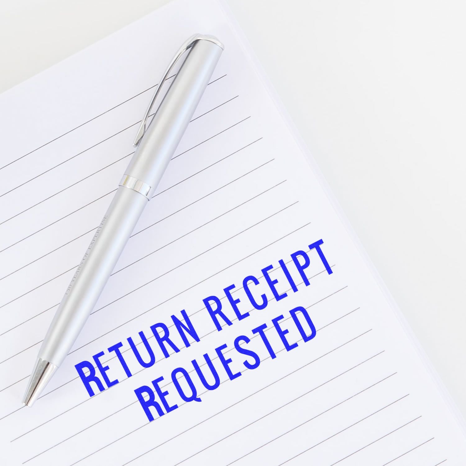 Silver pen on lined paper with Return Receipt Requested text, business mailing and postal confirmation concept.