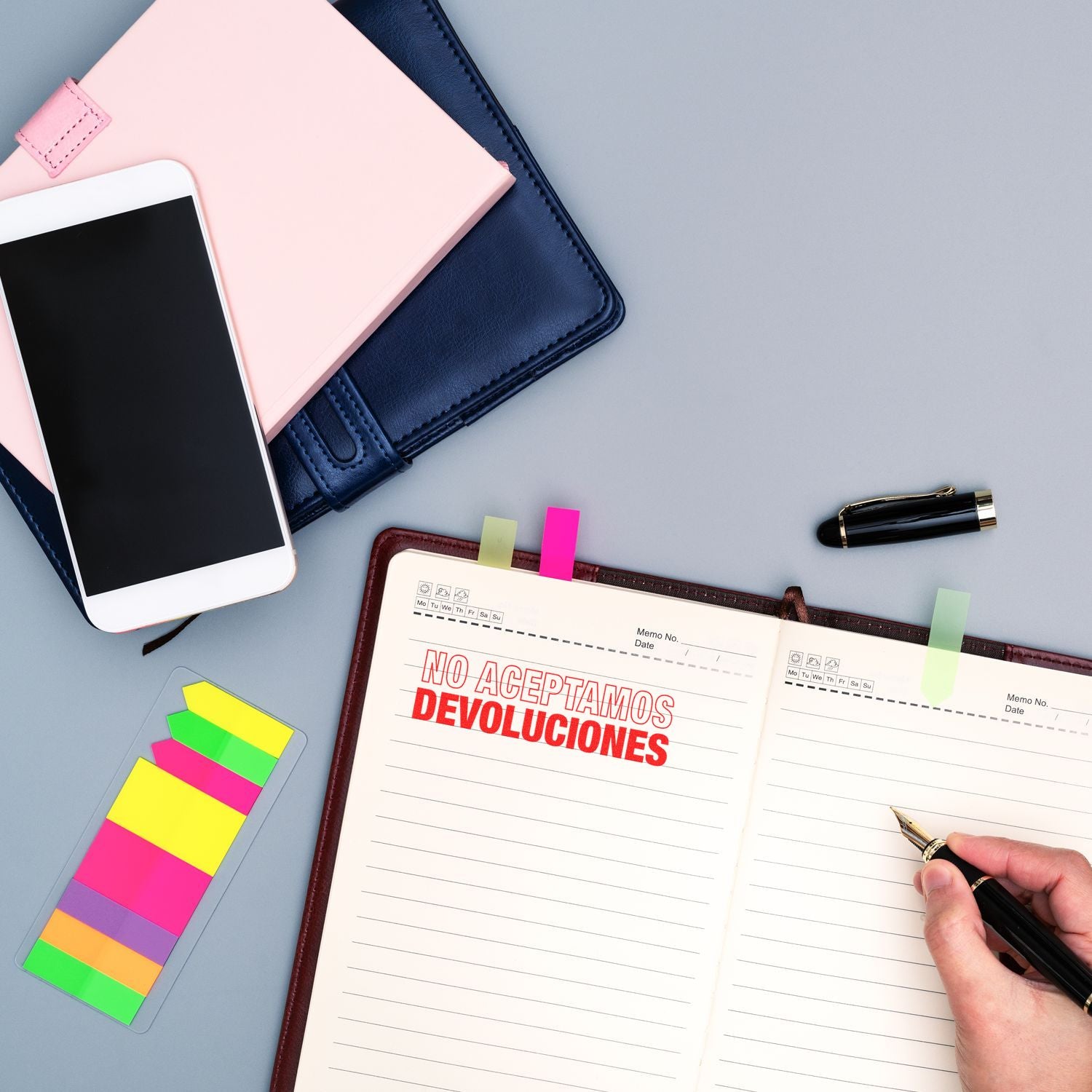 Spanish note No aceptamos devoluciones on planner with phone and pen, showing a strict no-returns policy for customers.