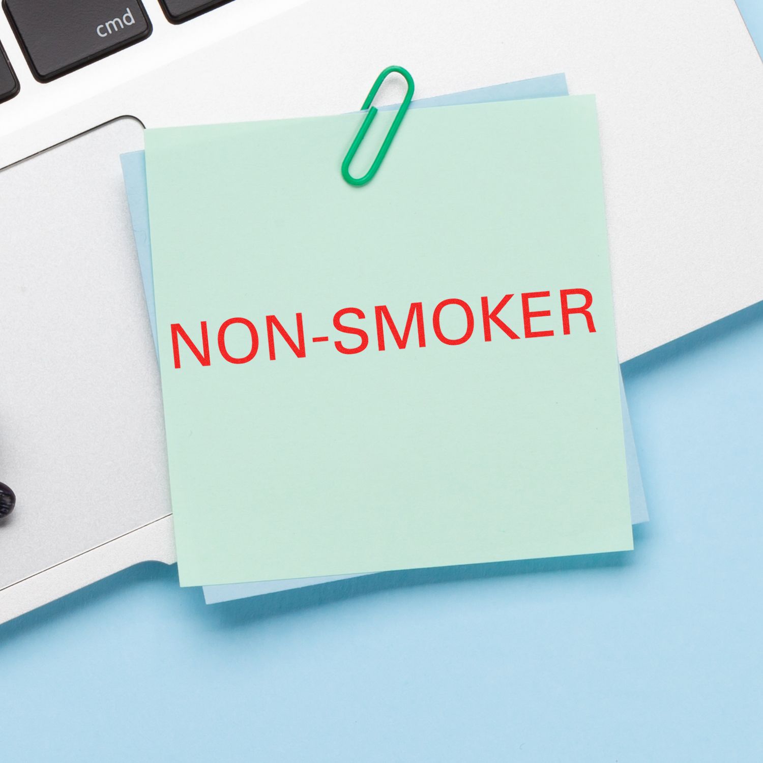 Sticky note labeled NON-SMOKER on office desk, indicating non-smoking status for health and safety.