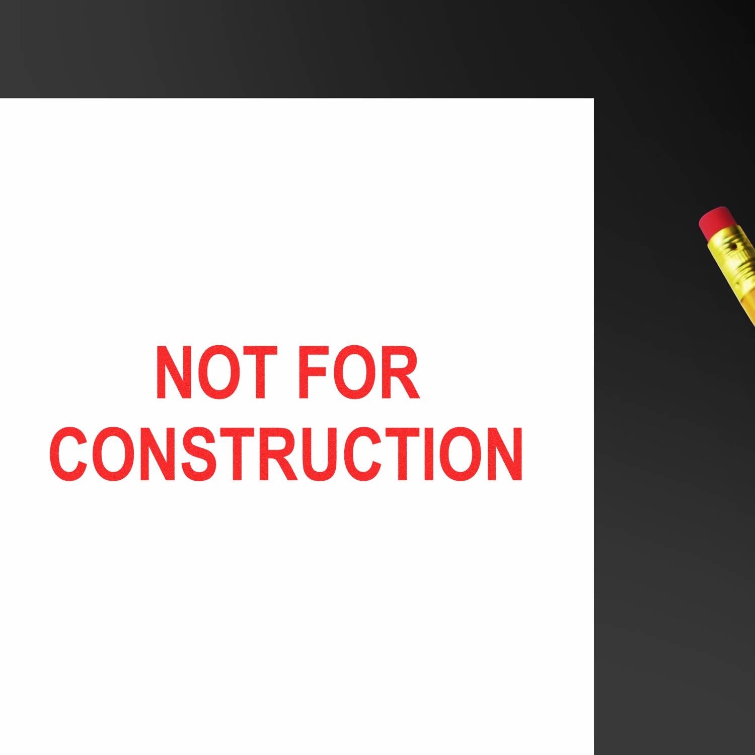 White paper with red Not For Construction text and pencil on dark background, concept for construction plans and design review.