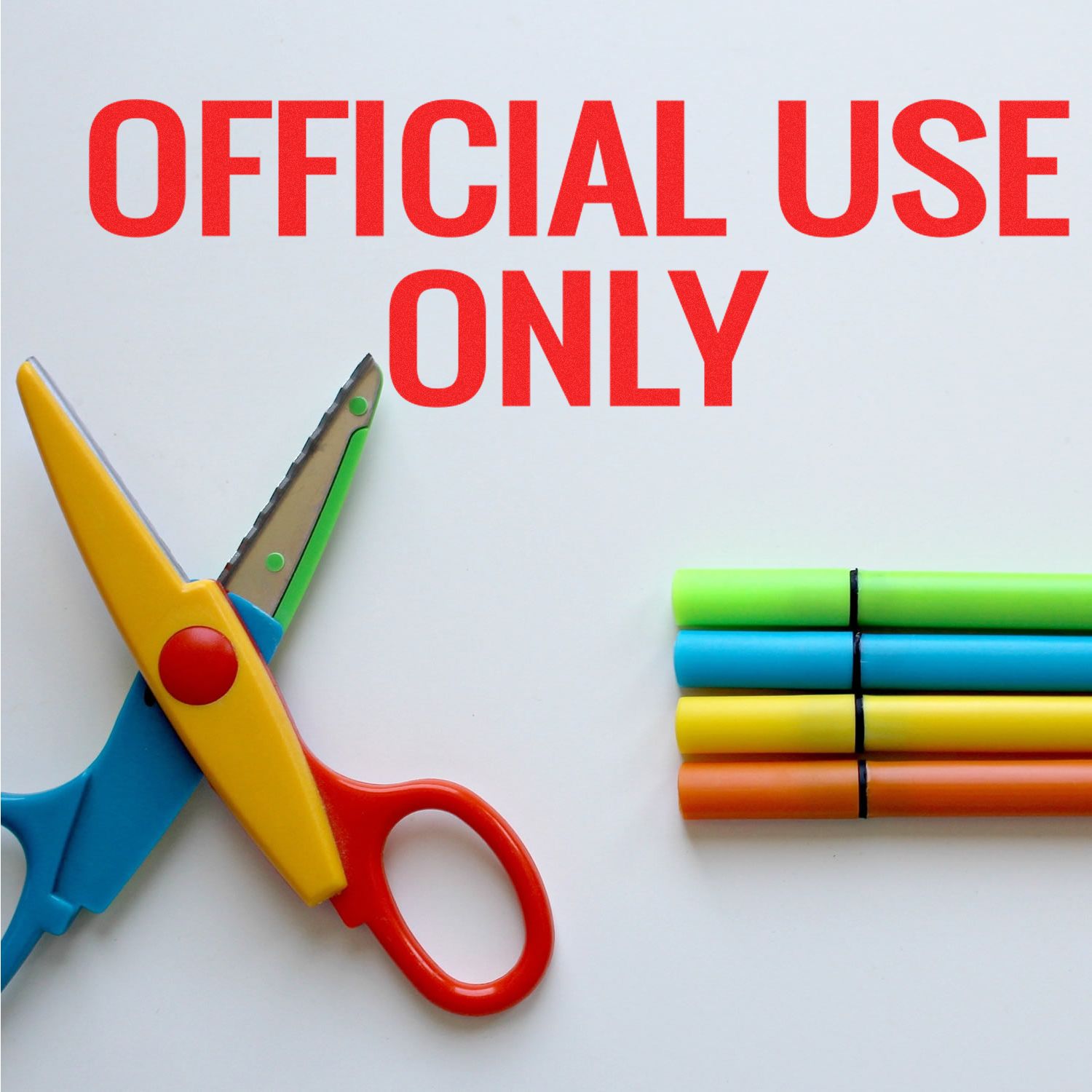Official use only sign with colorful safety scissors and markers on a white background.