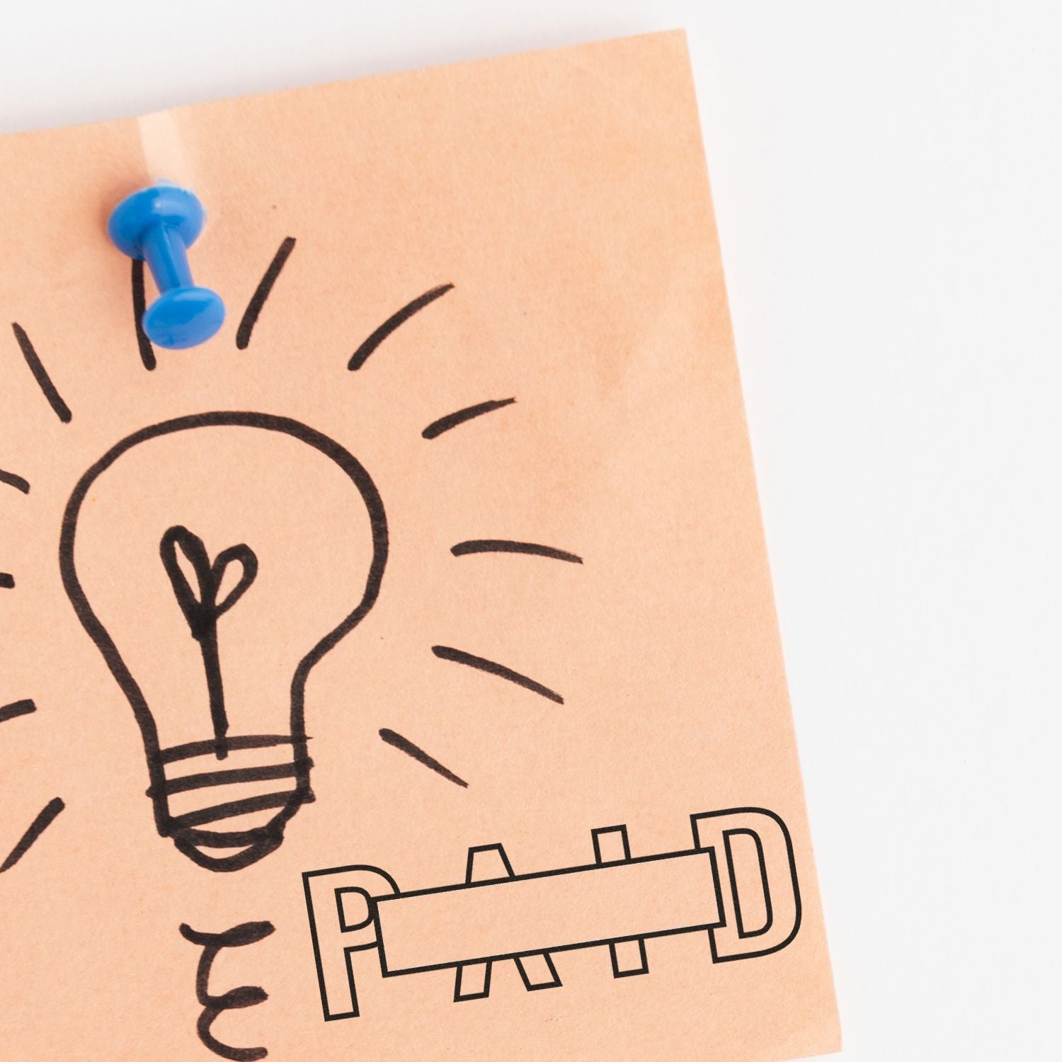 Sticky note with lightbulb idea sketch and bed icon pinned with a blue pushpin, symbolizing sleep and creative thinking.