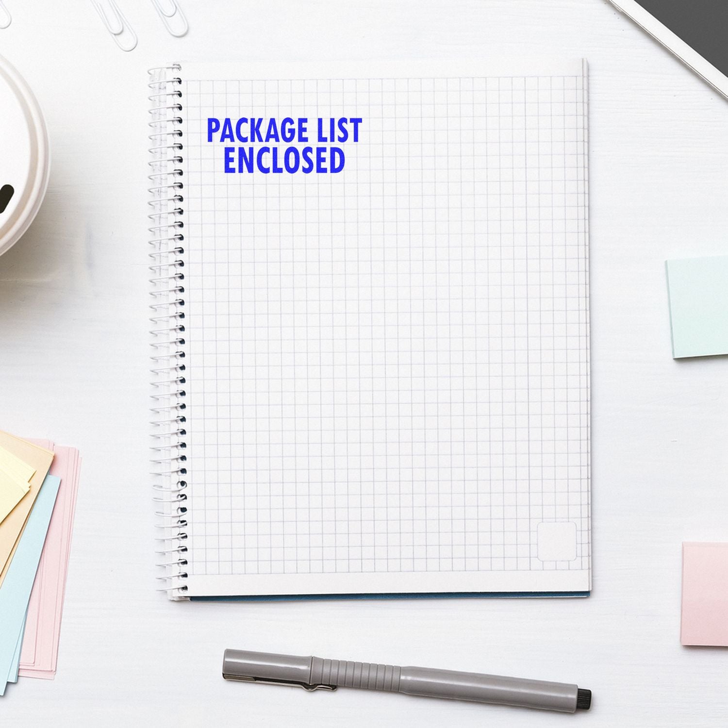 Package list enclosed message on open notebook with office supplies, indicating included shipping paperwork and order contents.