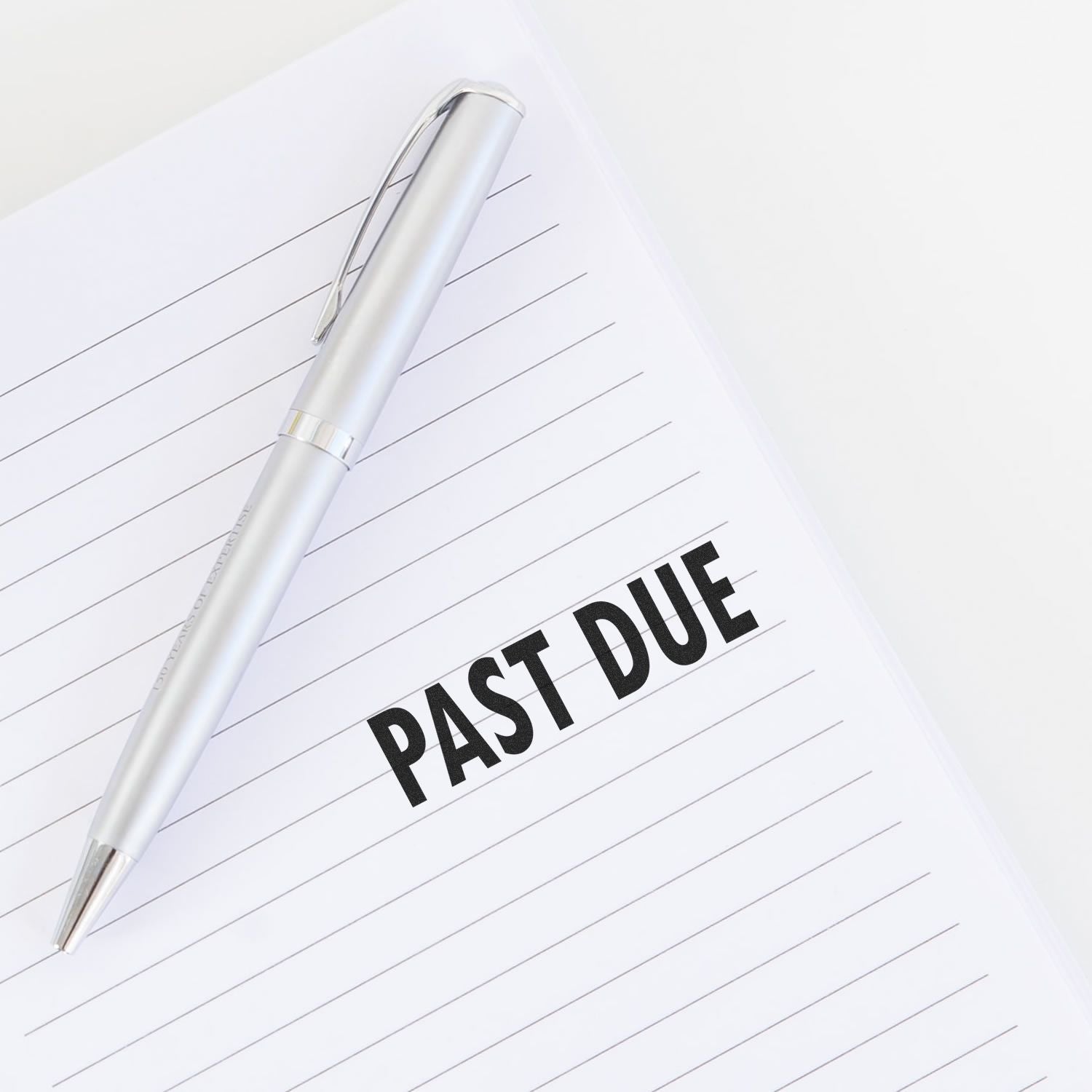 Silver pen on a lined document labeled PAST DUE, highlighting overdue invoices and late payment reminders.