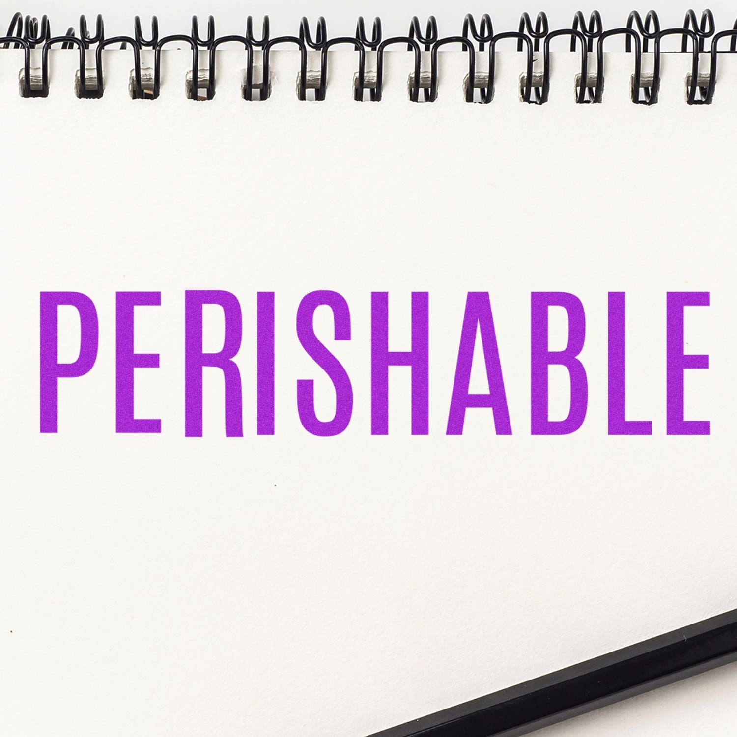 Perishable warning text in purple on a spiral notebook page, food safety label concept