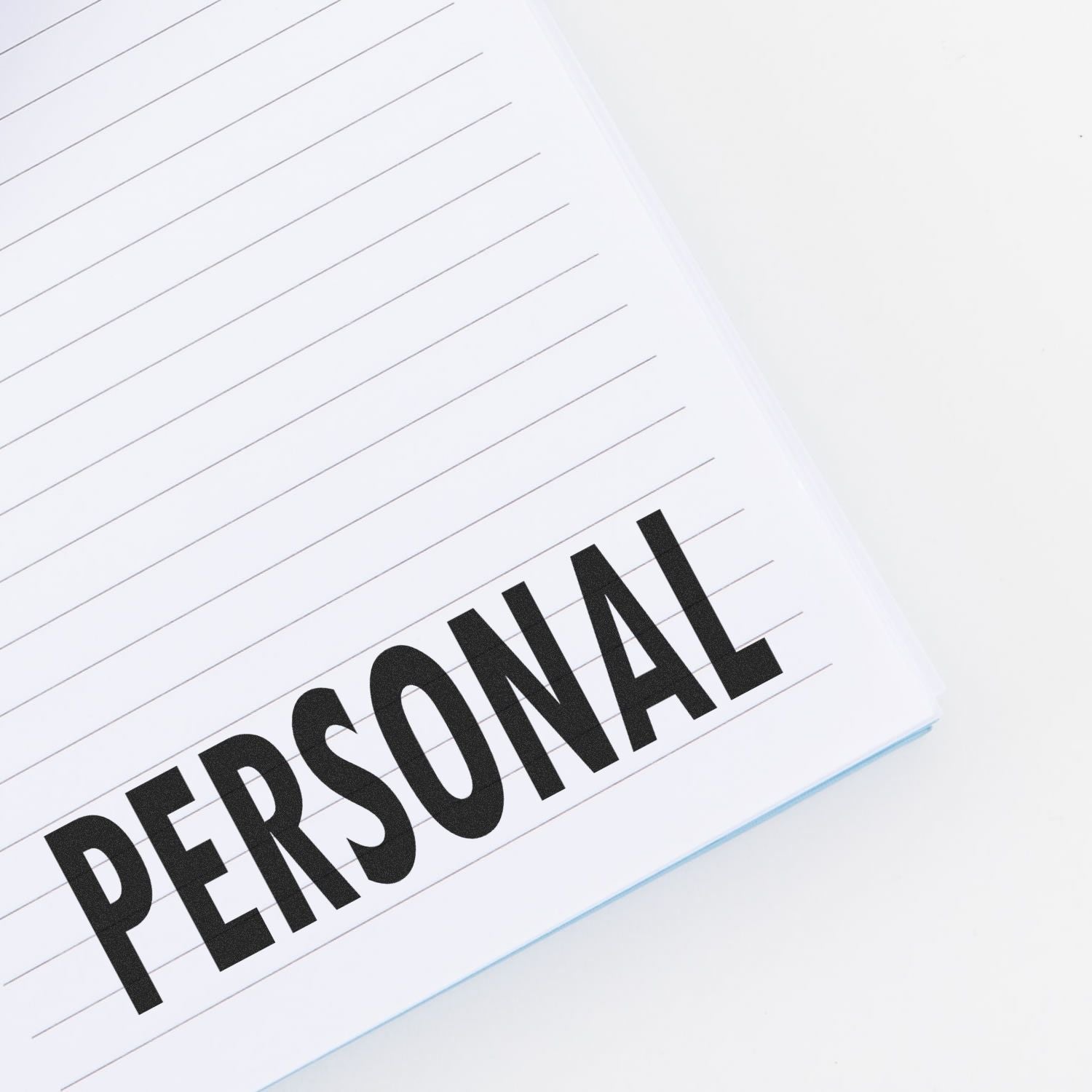 Close-up of a lined notebook page with the word PERSONAL in bold black text, symbolizing private notes, journaling, and personal information.