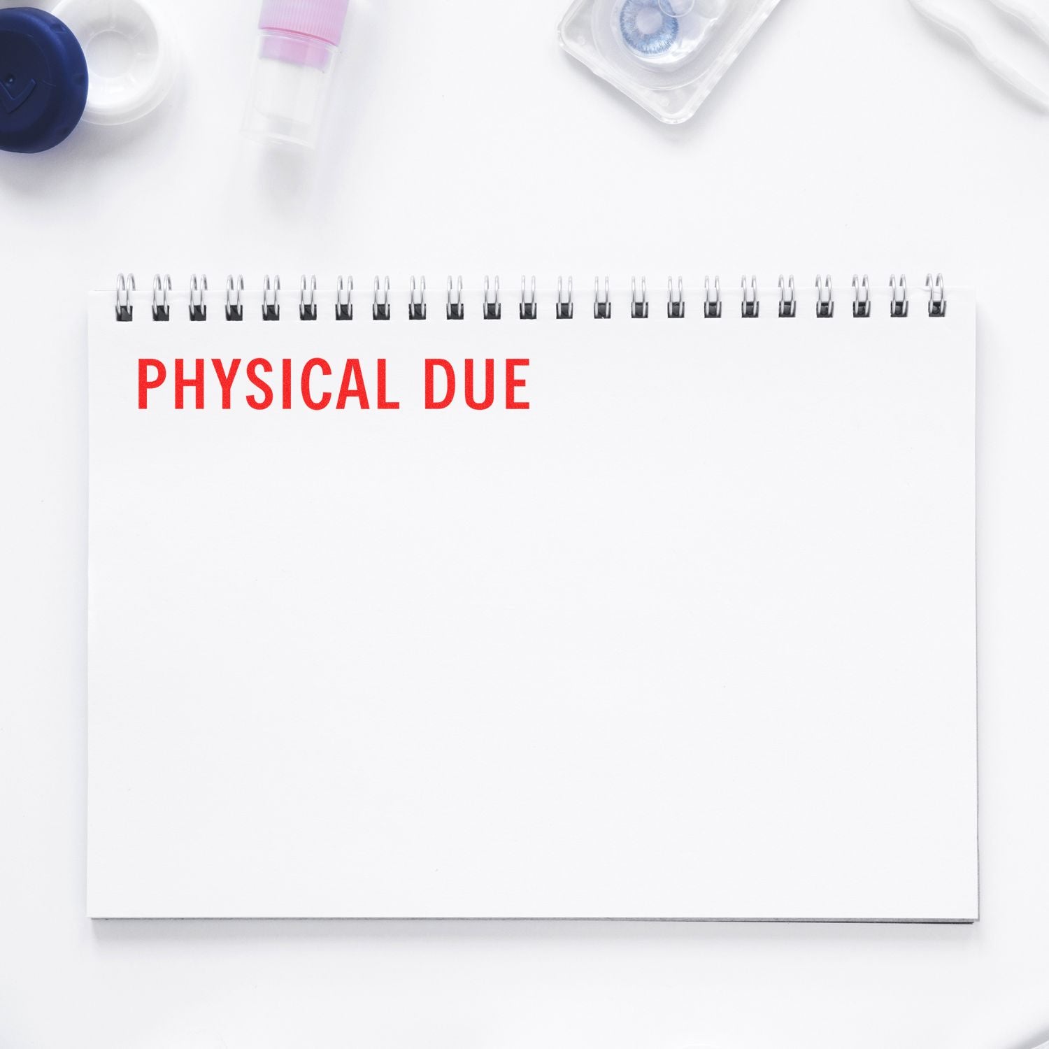 Notebook titled PHYSICAL DUE with medical supplies, highlighting an upcoming physical exam and healthcare appointment reminder