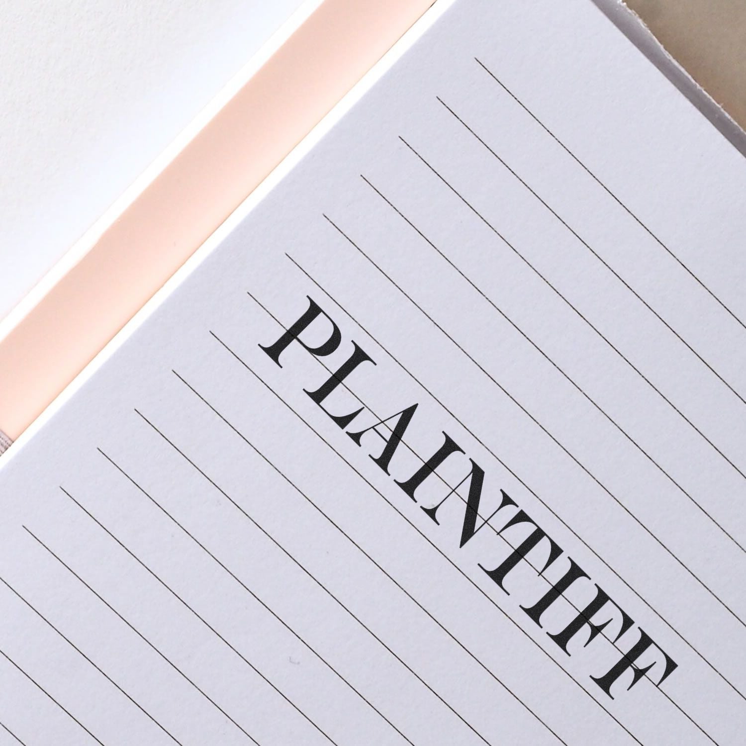 Close-up of luxury black-letter typography on white lined paper, highlighting premium design branding and printed materials.