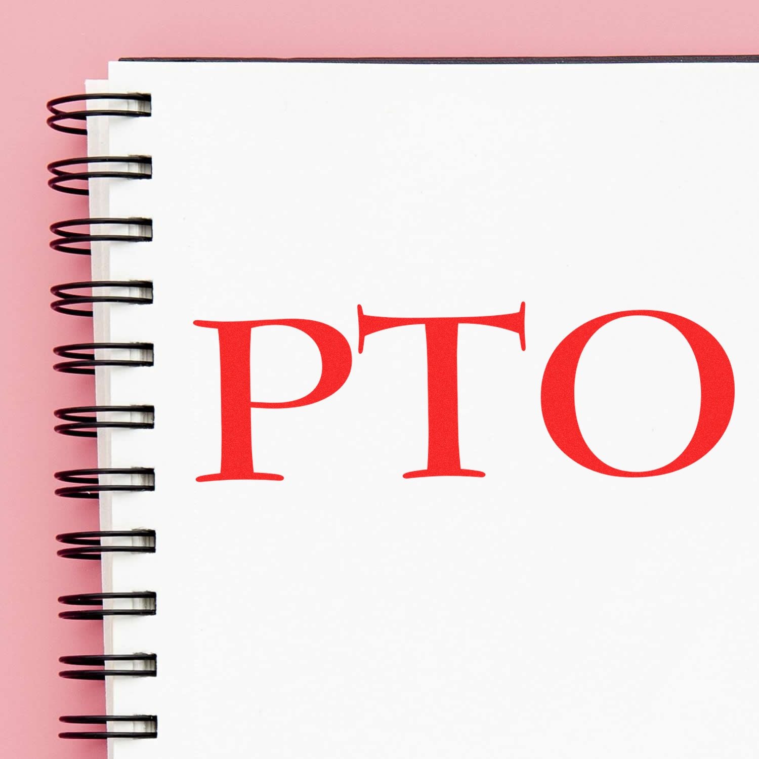 Notebook with spiral binding and red PTO letters, highlighting paid time off planning for employees and vacation scheduling calendar.