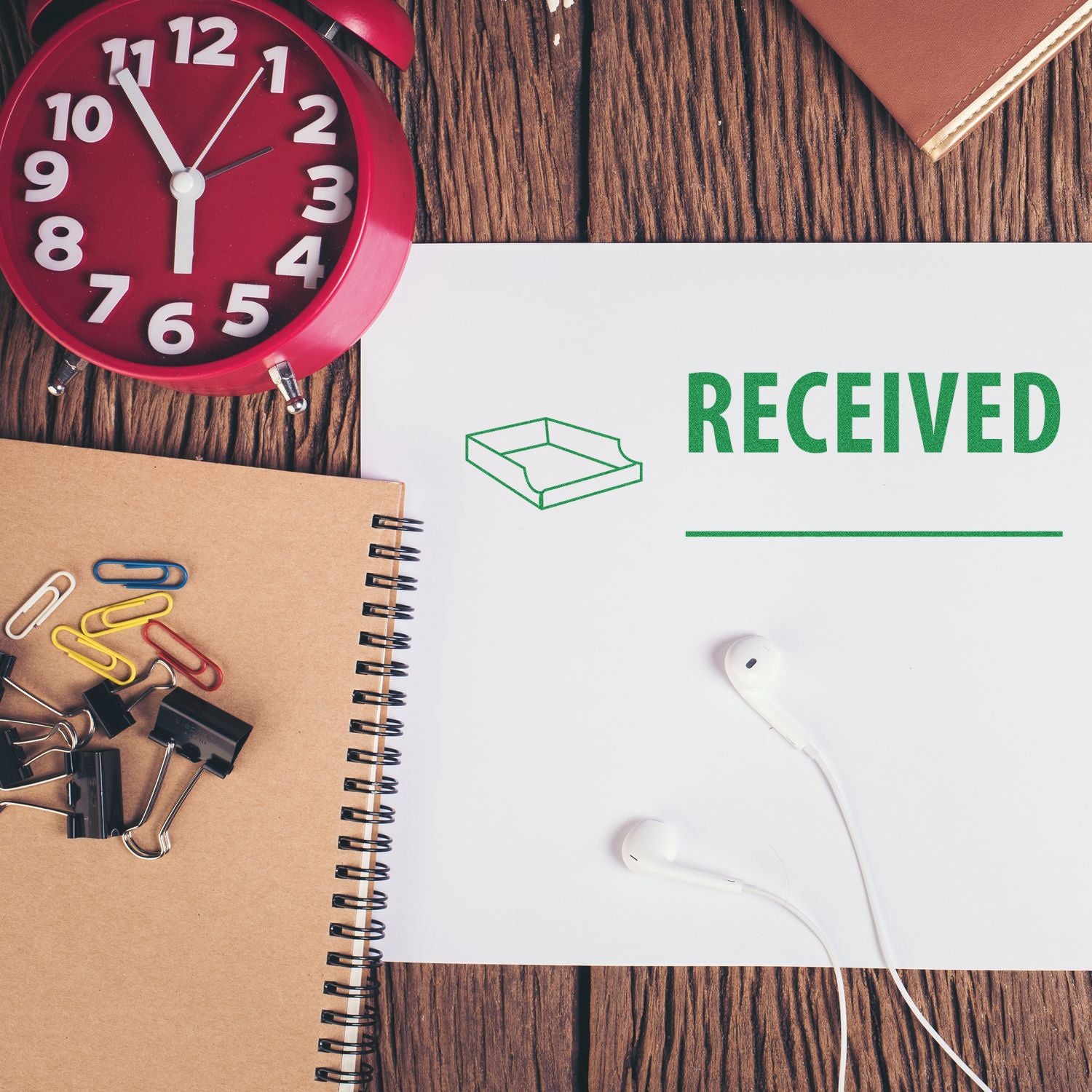 Received confirmation concept: desk supplies and headphones with an alarm clock and a RECEIVED banner.