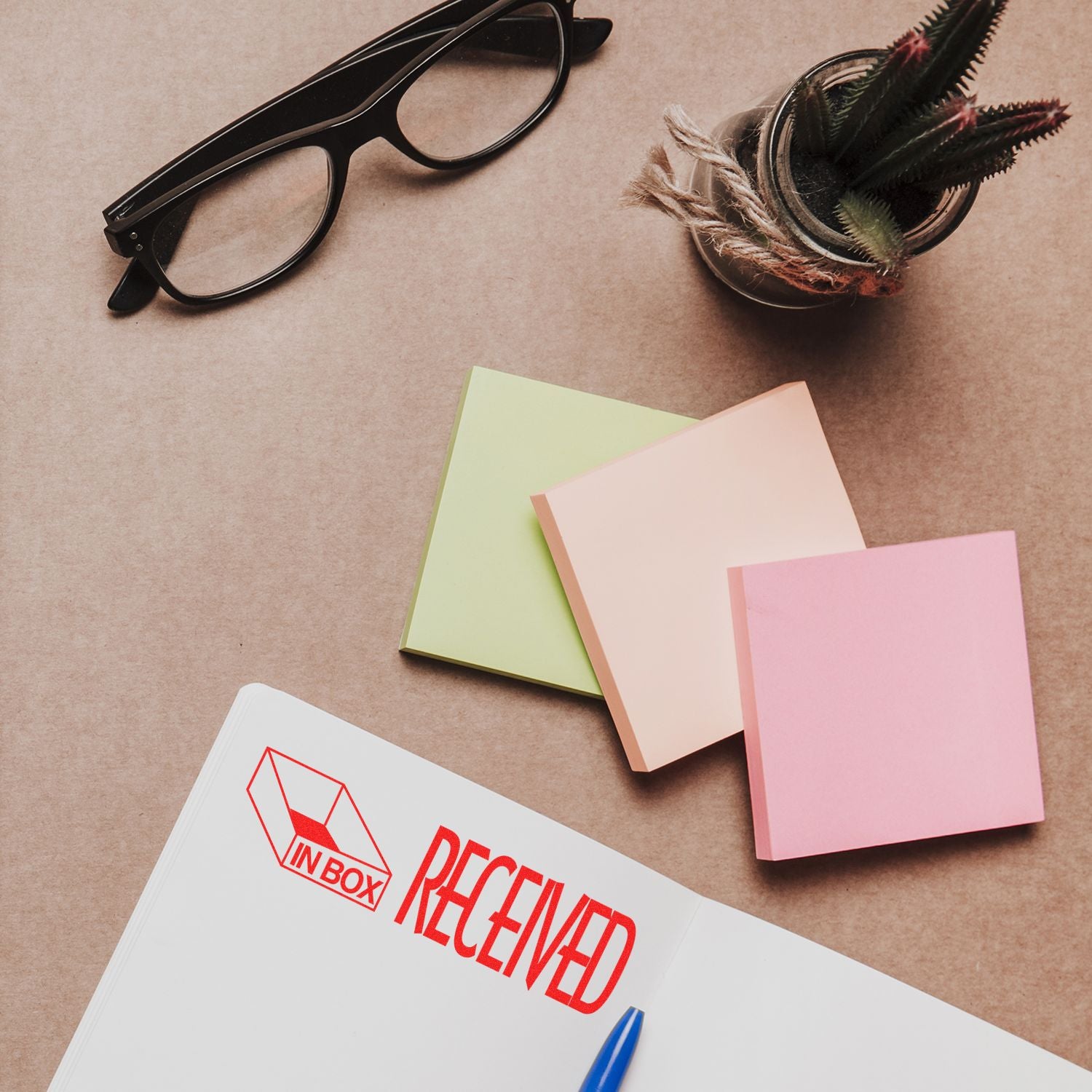 Creative stationery flat lay with eyeglasses, colorful notebooks, and quill ink, suggesting inbox organization and productivity planning.