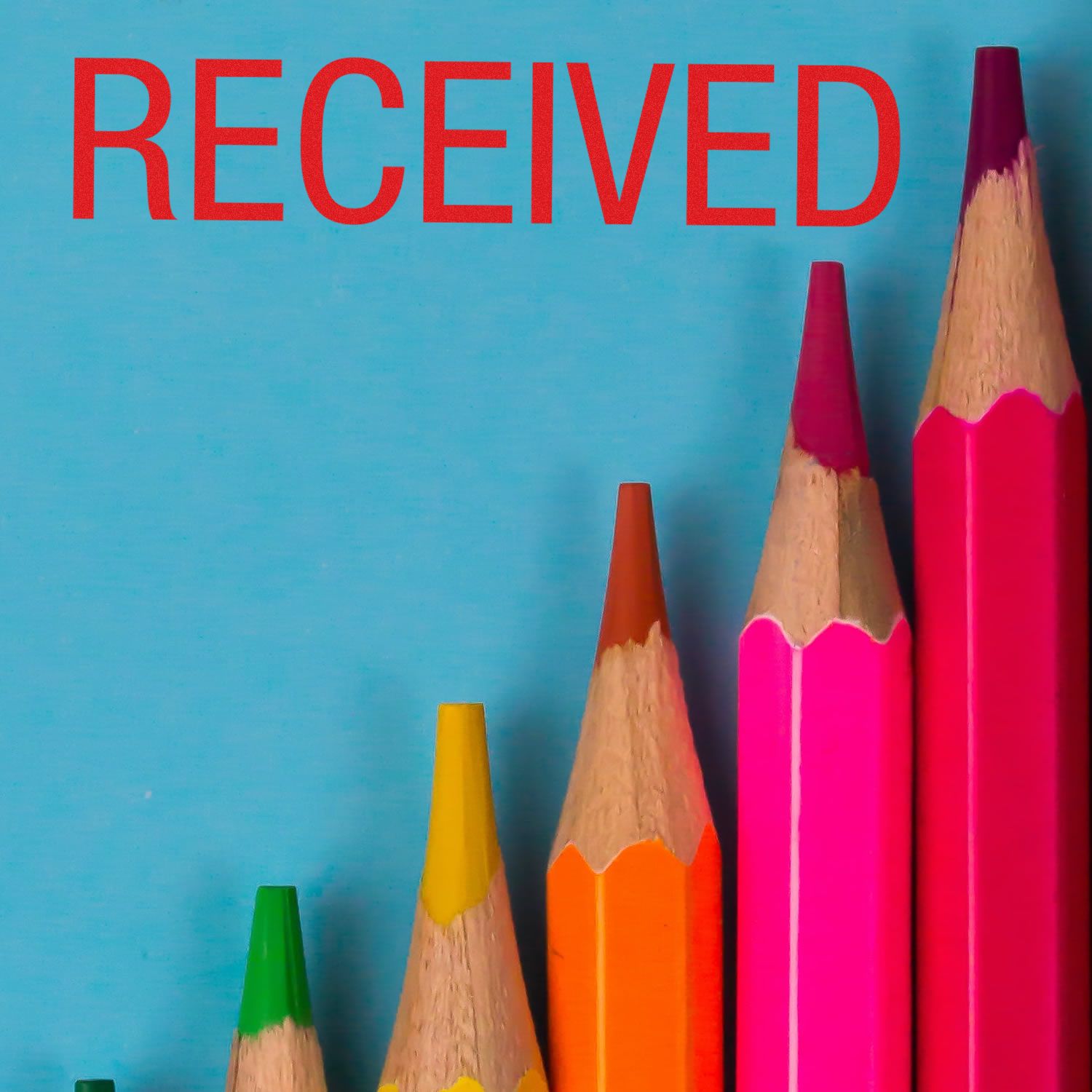Received confirmation concept with colored pencils on blue background and bold 'RECEIVED' text for email or package delivery status
